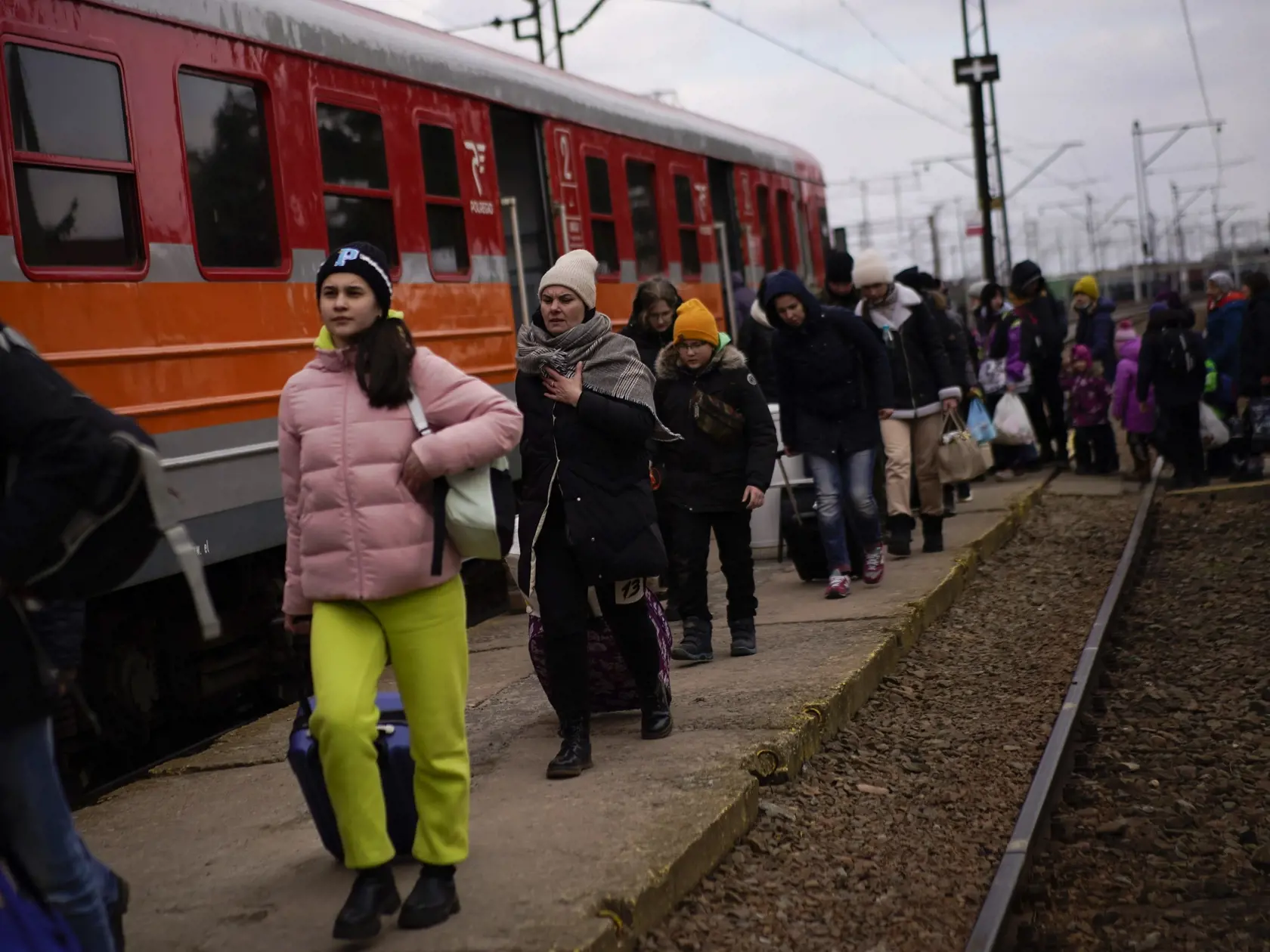 JB 37 Medyka - Utečenci utekajúci pred vojenským konfliktom na Ukrajine kráčajú okolo vlaku po ich príchode na poľsko-ukrajinský hraničný priechod Medyka na hraniciach s Poľskom 10. marca 2022. Vysoký komisár OSN pre utečencov Filippo Grandi v utorok uviedol, že počet utečencov z Ukrajiny už prekonal hranicu dvoch miliónov. TASR o tom informovala na základe správy od agentúry AP. Viac ako polovica ľudí utekajúcich pred vojnou prišla do Poľska. Tamojšia pohraničná stráž v utorok ráno evidovala vy