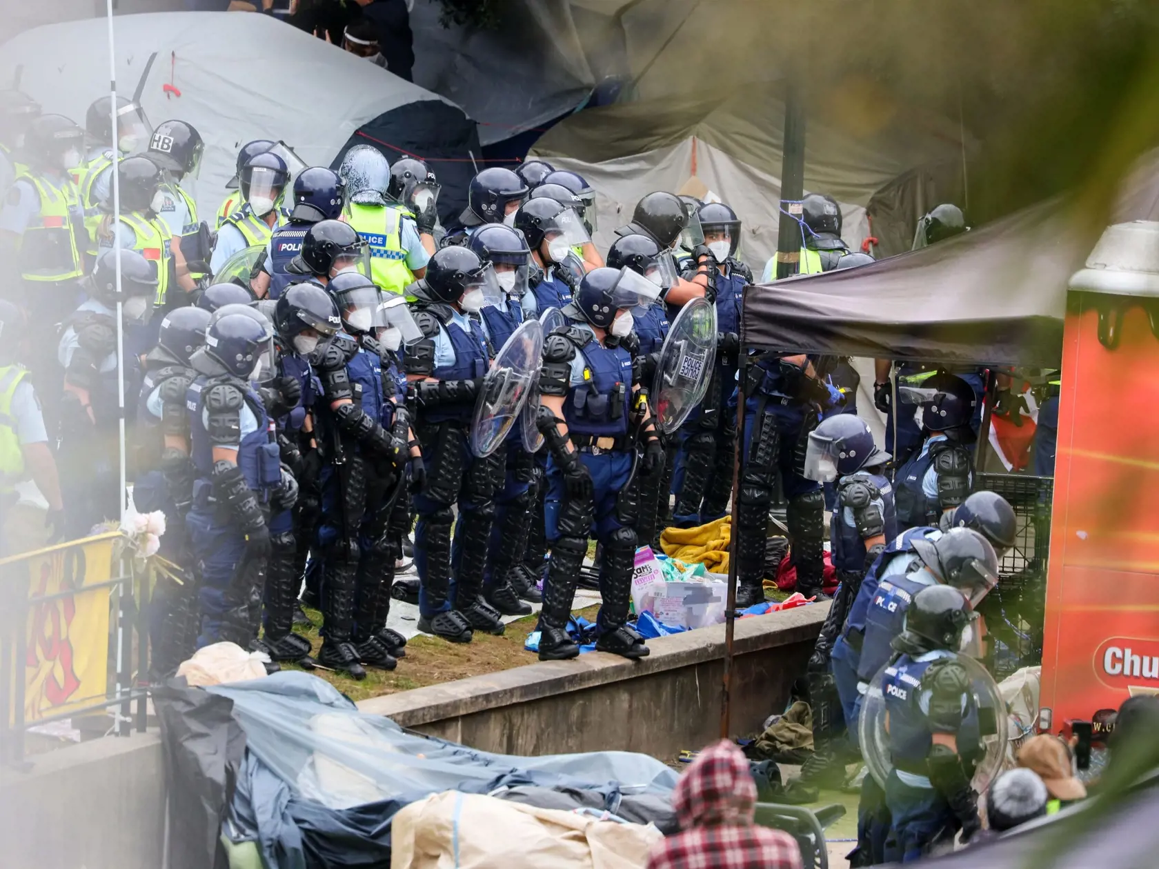 Na snímke demonštranti proti povinnému očkovaniu na Novom Zélande a príslušníci polície počas incidentu v protestnom tábore pred parlamentom vo Wellingtone v stredu 2. marca 2022.