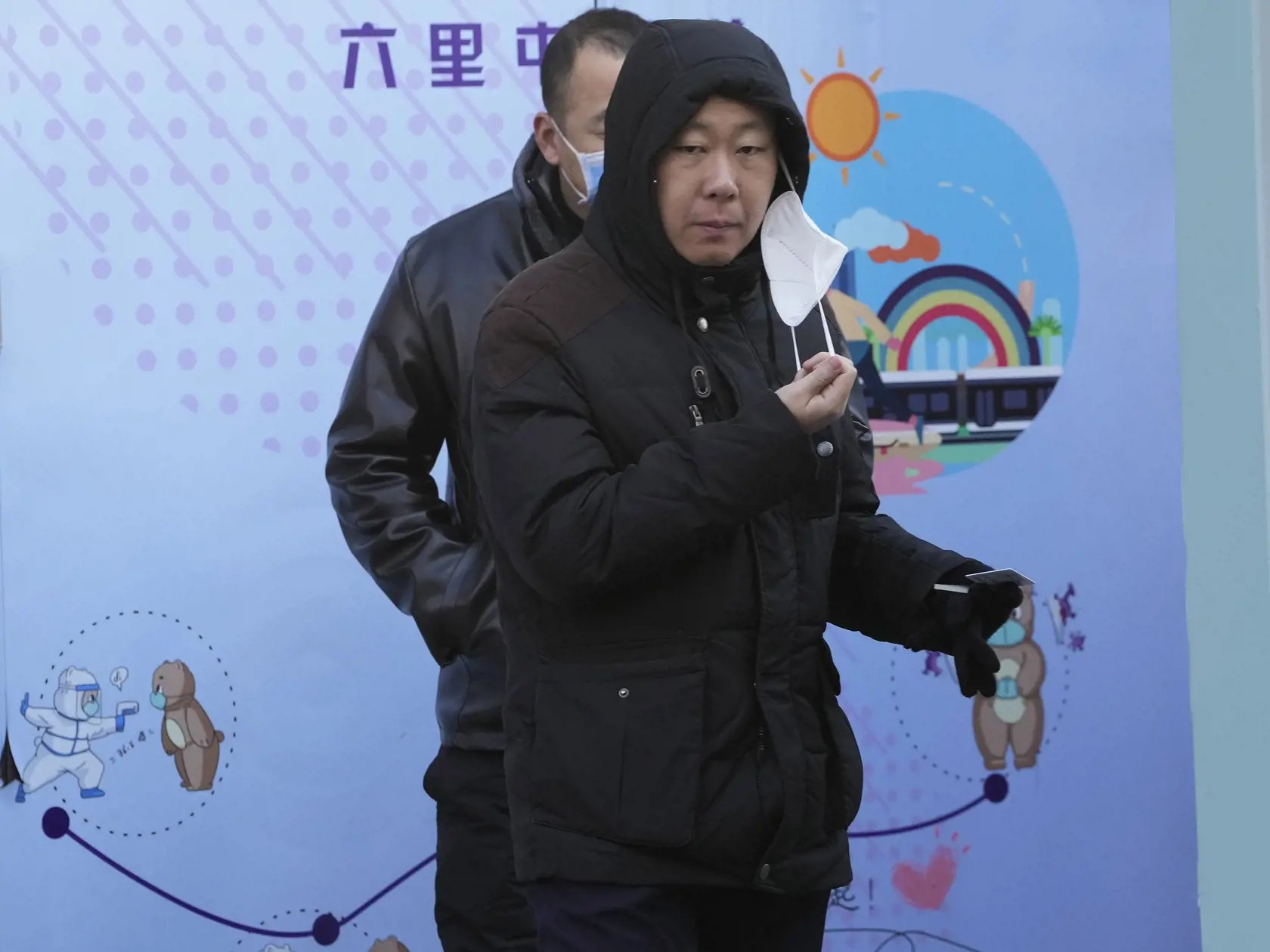 Na snímke muž si sníma respirátor pred testovaním na prítomnosť vírusu COVID-19 v čínskom Pekingu 7. decembra 2022.