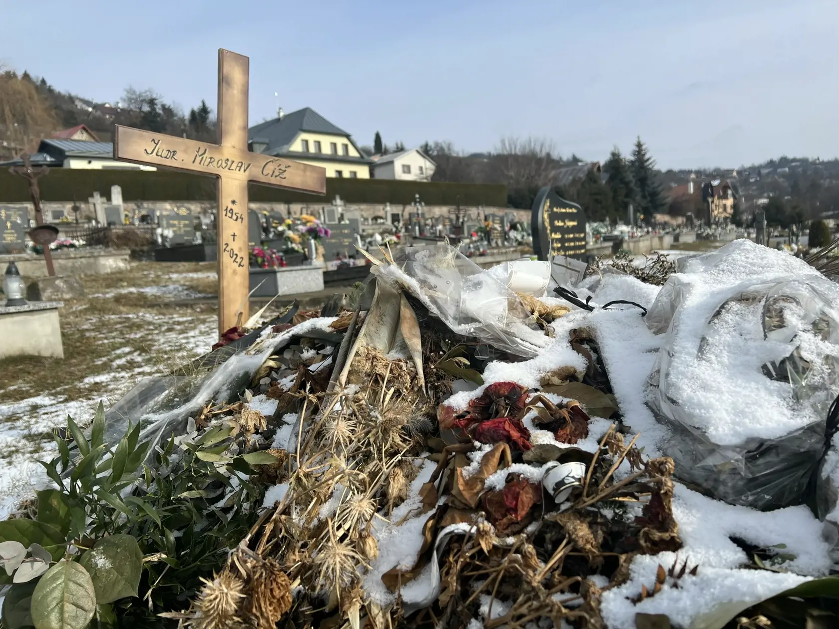 Namiesto pomníka tu dočasne stojí len jednoduchý drevený kríž a hrob pôsobí ako keby sa oň nik nestaral - ležia na ňom staré kvety ešte od pohrebu.