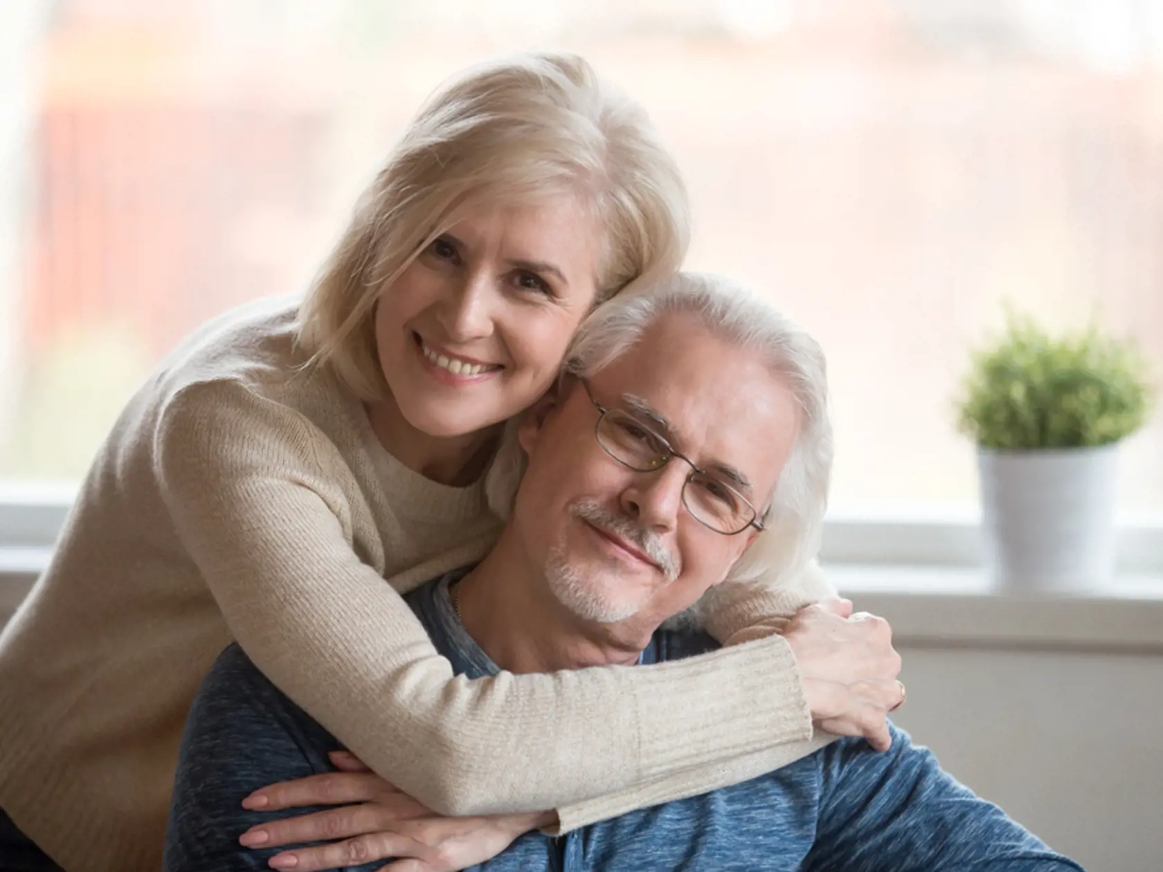 Smiling,Caring,Middle,Aged,Wife,Embracing,Senior,Husband,At,Home,