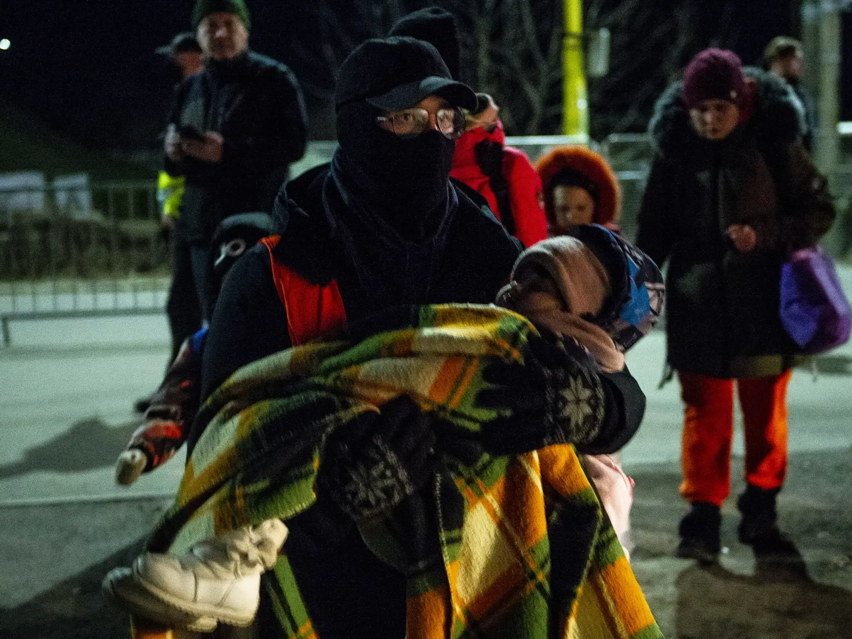 Na snímke dobrovoľník odnáša dieťa utečencov z Ukrajiny do stanu na slovensko-ukrajinskom hraničnom priechode v obci Vyšné Nemecké, okres Sobrance  v sobotu 12. marca 2022. FOTO TASR - Jakub Kotian