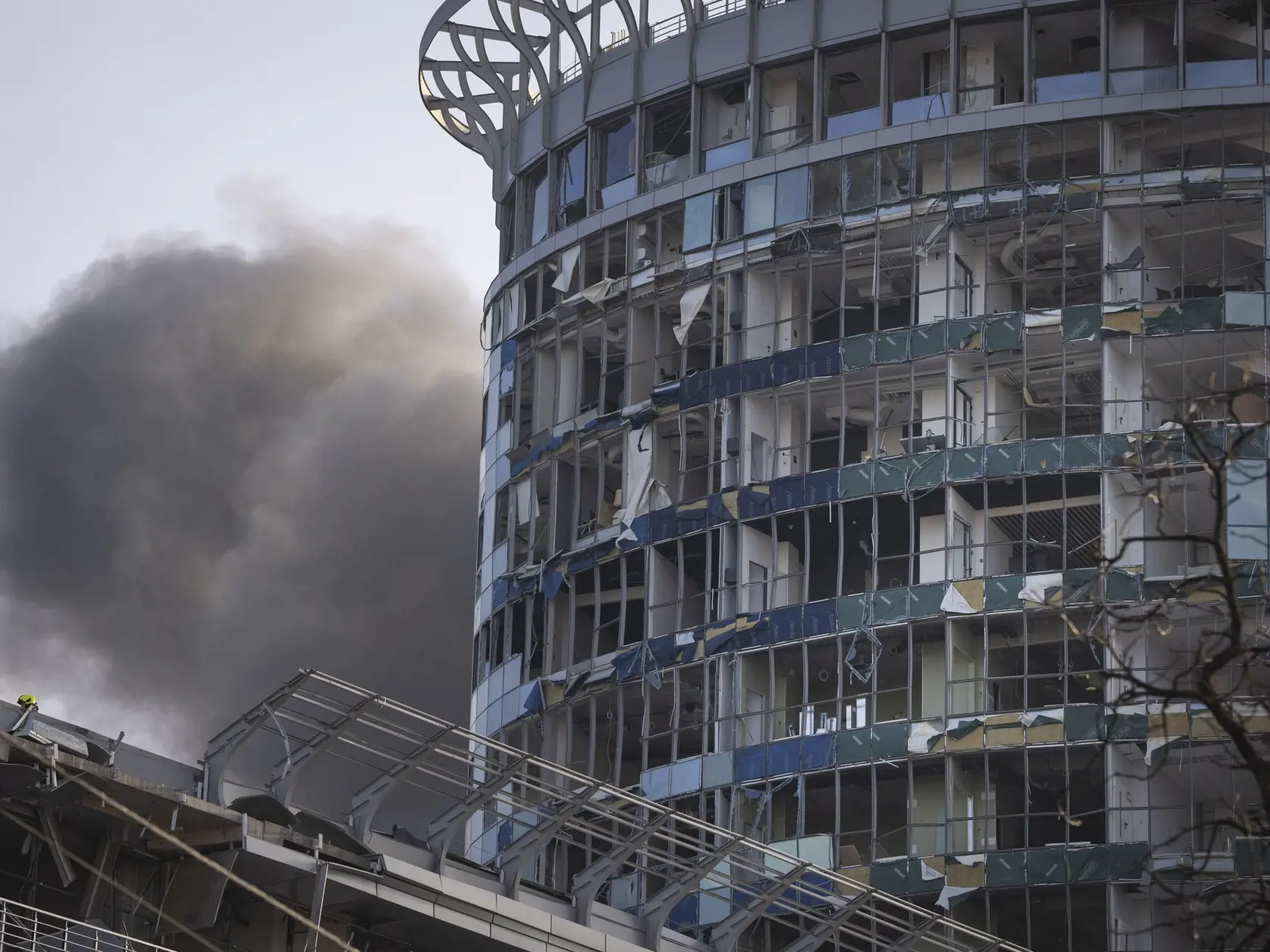 Dym stúpa za budovou poškodenou pri ruskom raketovom útoku v Kyjeve v piatok 29. decembra 2023.