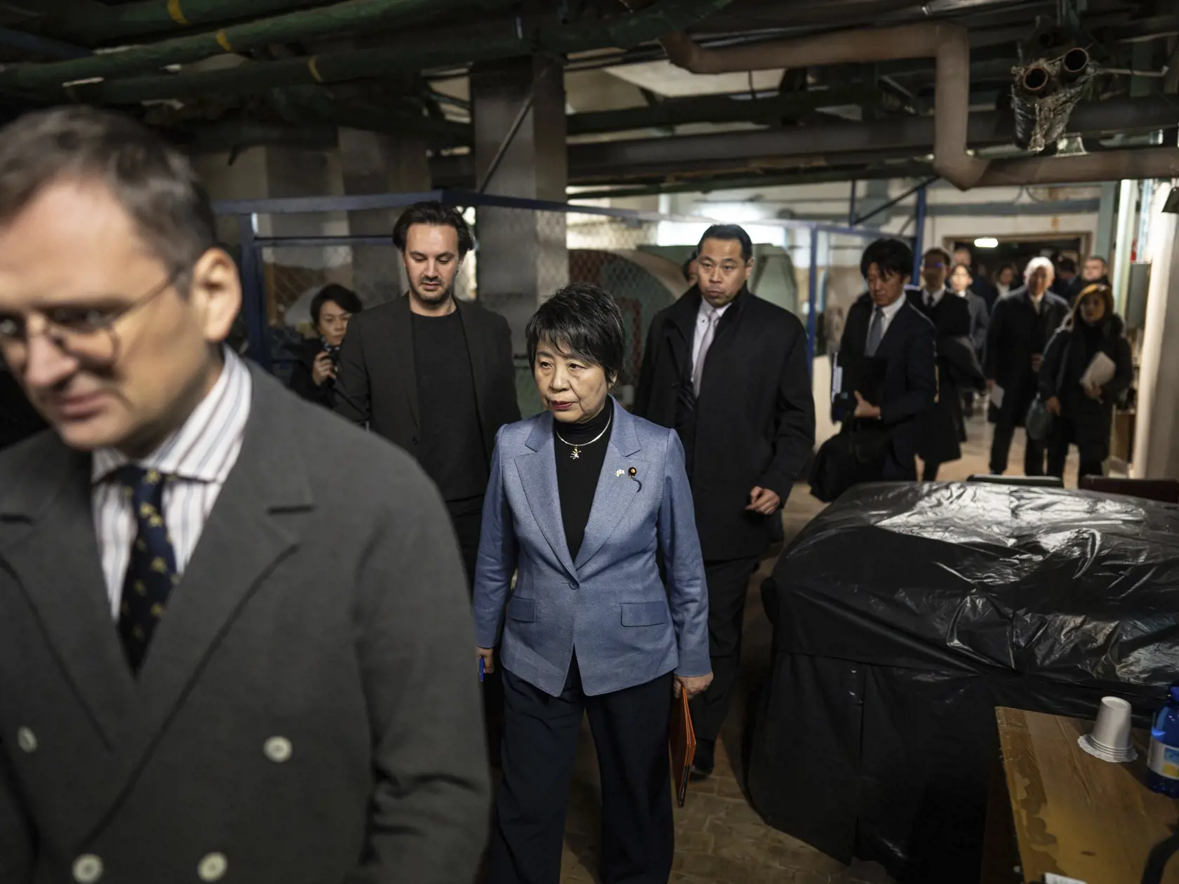 Ukrajinský minister zahraničných vecí Dmytro Kuleba (vľavo) a japonská šéfka diplomacie Jóko Kamikawaová kráčajú po chodbe bombového krytu počas leteckého poplachu v Kyjeve v nedeľu 7. januára 2024.