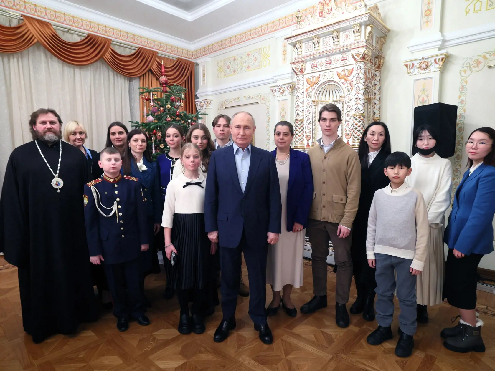 Ruský prezident Vladimir Putin (uprostred) pózuje s členmi rodiny padlých účastníkov vojny na Ukrajine v Katedrálnom chráme Krista Spasiteľa v Novo-Ogariove v metropolitnej oblasti Moskvy 7. januára 2024.