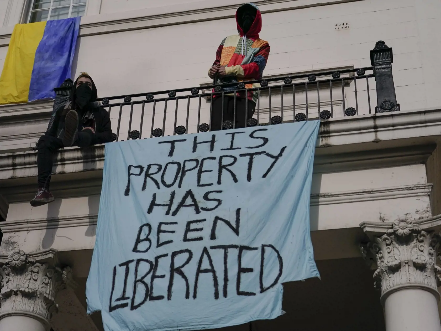 KK37Londýn - Squatteri vyvesili transparent a ukrajinskú vlajku na budove, ktorá pravdepodobne patrí ruskému oligarchovi 14. marca 2022 v Londýne.  Squatterom sa v Londýne podarilo preniknúť do rezidencie na námestí Belgrave, ktorú vlastní ruský oligarcha Oleg Deripaska. FOTO TASR/AP