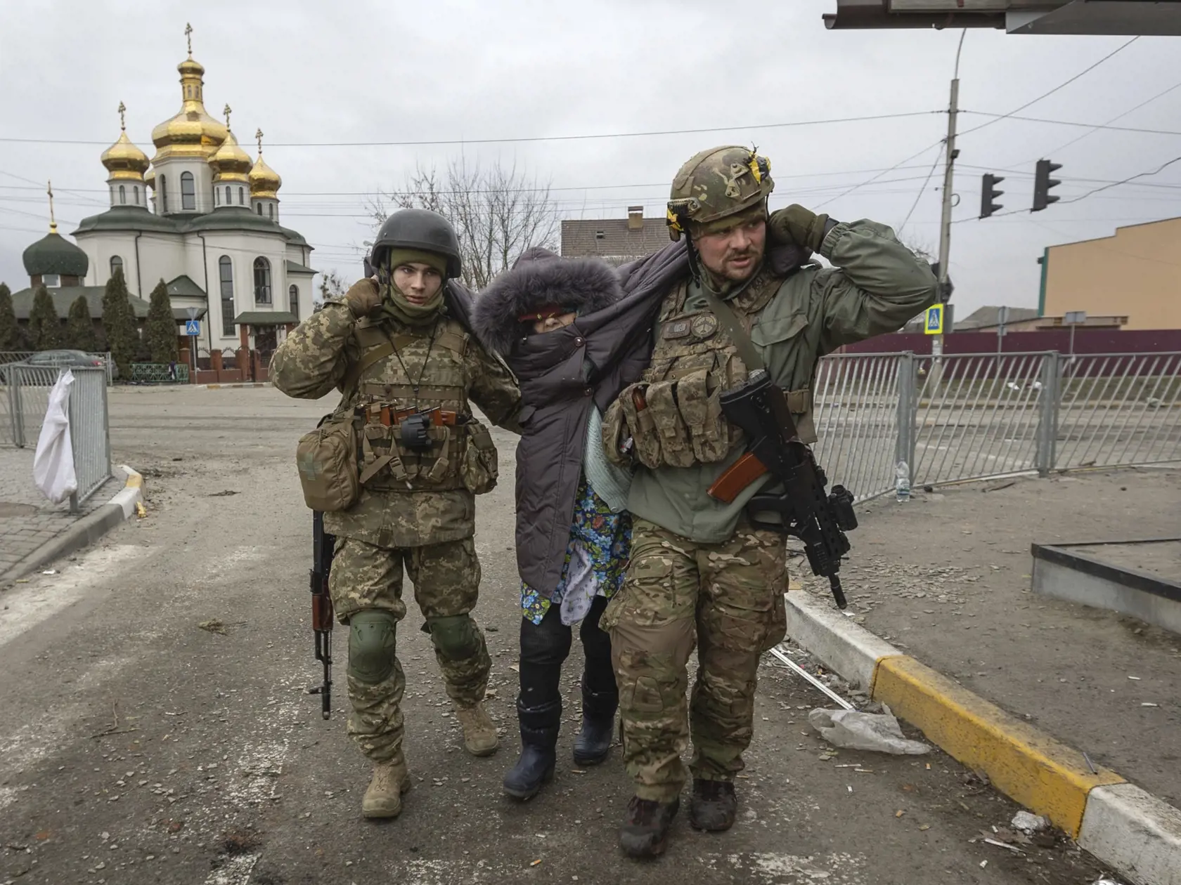 WA 56 Irpiň - Ukrajinskí  vojaci pomahajú staršej žene v meste Irpiň počas jedenásteho dňa ruskej invázie na Ukrajine v nedeľu 6. marca 2022. FOTO TASR/AP 
 
Ukrainian servicemen help an elderly woman, in the town of Irpin, Ukraine, Sunday, March 6, 2022. With the Kremlin's rhetoric growing fiercer and a reprieve from fighting dissolving, Russian troops continued to shell encircled cities and the number of Ukrainians forced from their country grew to over 1.4 million. (AP Photo/Andriy Dubchak)