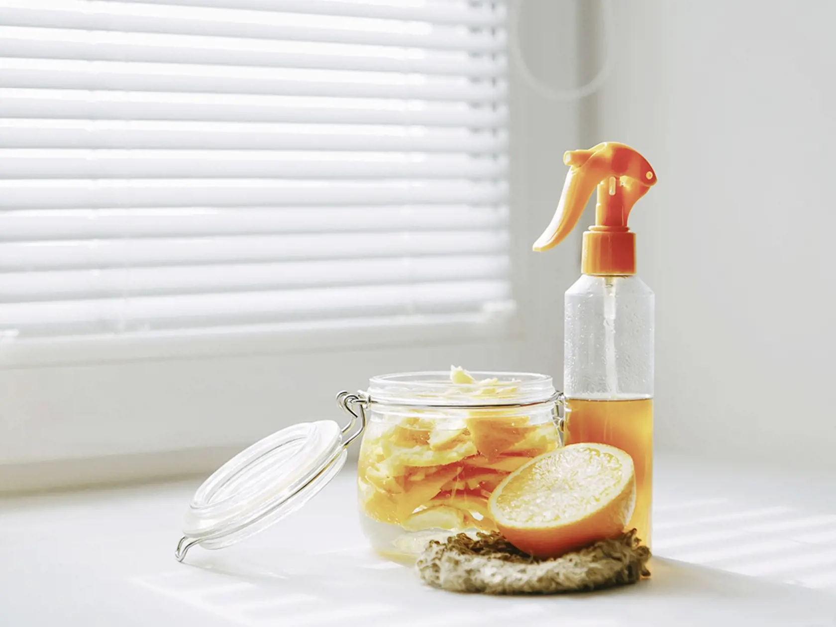 DIY cleaning spray, natural toxic free home cleaner, orange peel infused vinegar in bathroom. Zero waste homemade citrus cleaner for all purpose cleaning. Eco friendly sustainable living concept. 