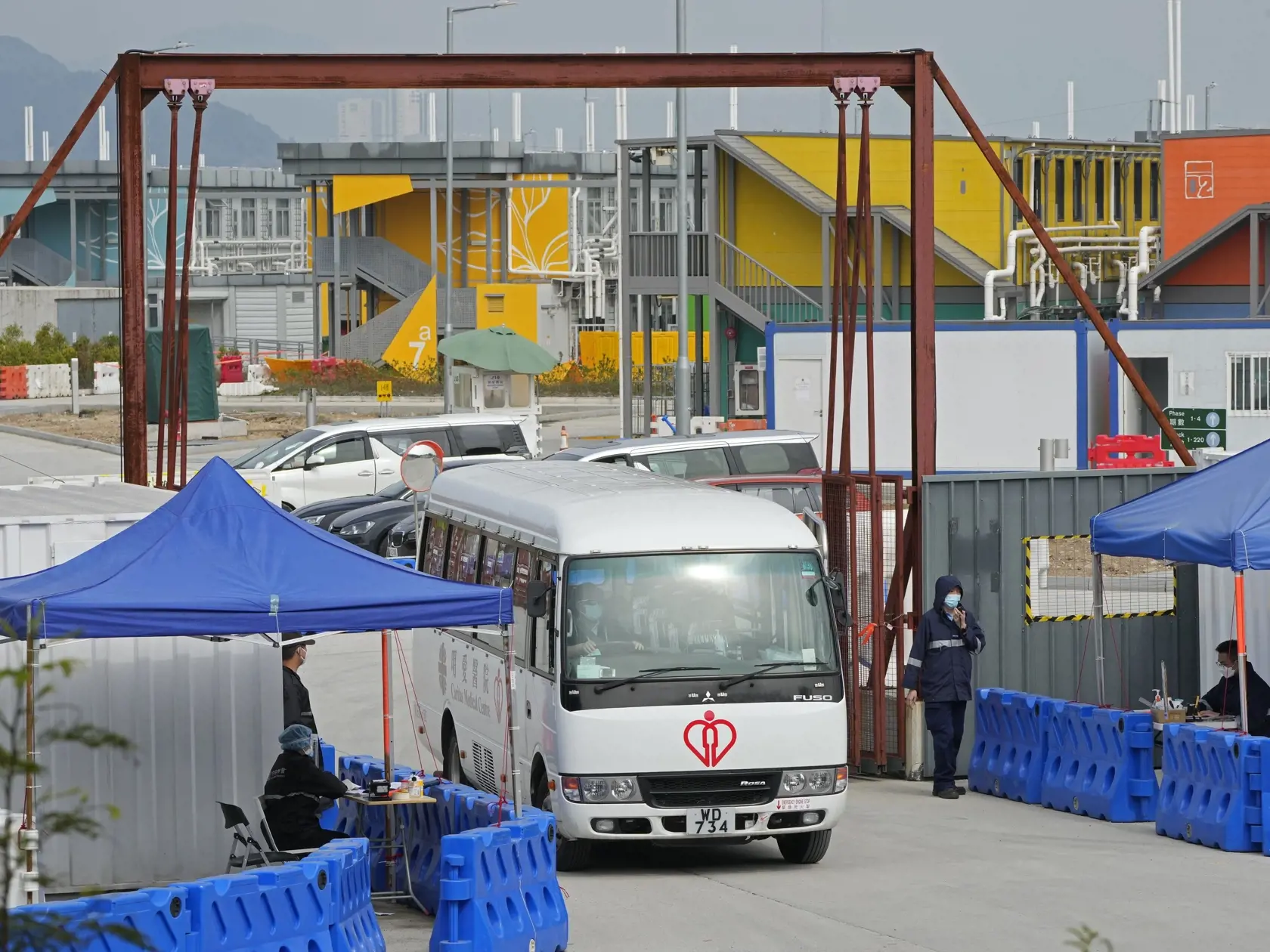 JB 34 Hongkong - Nemocničná dodávka vychádza z karanténneho centra, kde sú izolačné jednotky pre pacientov s ochorením COVID-19 na ostrove  Lantau v Hongkongu 24. februára 2022. Hongkonská vláda vo štvrtok uplatnila mimoriadne právomoci, aby umožnila lekárom a zdravotným sestrám z iných oblastí Číny pôsobiť v tomto meste, ktoré aktuálne zápasí s prudkým nárastom počtu nakazených koronavírusom. TASR prevzala správu z agentúry AFP. Hongkonská vláda vo vyhlásení uviedla, že schválené nariadenie umo