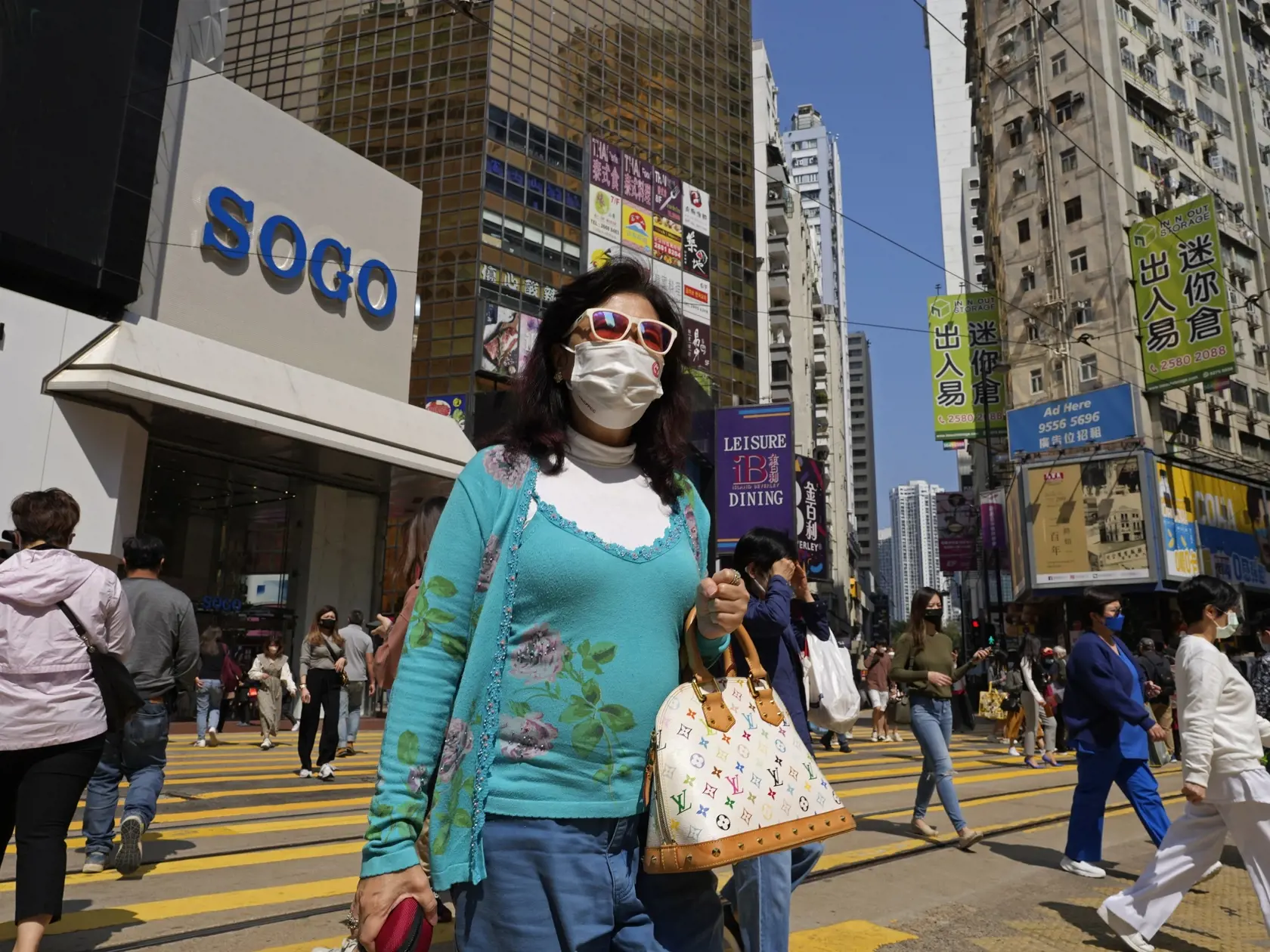 EBE 19 Hongkong - Žena s ochranným rúškom prechádza cez ulicu v centre Hongkongu vo štvrtok 3. marca 2022. Keďže nové prípady nakazených koronavírusom stále pribúdajú, zdravotnícke úrady uviedli, že vláda môže zaviesť nové opatrenia. FOTO TASR/AP

A woman wearing face mask walks across a downtown street in Hong Kong, Thursday, March 3, 2022. As COVID cases continue to rise, health authorities said the government could implement measures that may involve "asking people to stay at home," and that 