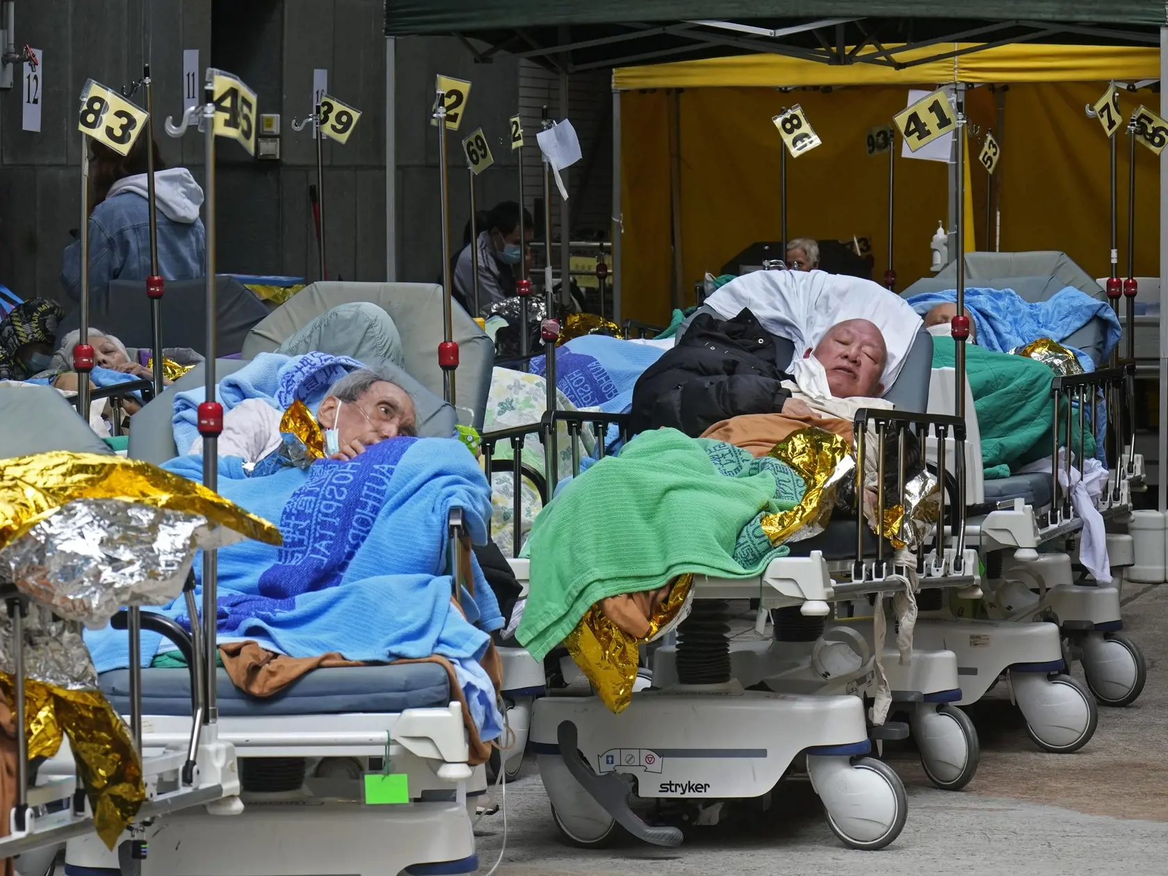 JB 49 Hongkong - Pacienti ležia na nemocničných lôžkach a čakajú v provizórnych priestoroch pred zdravotníckym zariadením v Hongkongu 16. februára 2022. Čínsky prezident a generálny tajomník ústredného výboru komunistickej strany Si Ťin-pching vyzval regionálnu vládu v Hongkongu, aby prijala všetky potrebné opatrenia na zastavenie rozsiahleho šírenia koronavírusového variantu omikron. Informovala o tom v stredu agentúra AFP. Hongkong v súčasnosti zažíva doposiaľ najhoršiu vlnu šírenia koronavíru