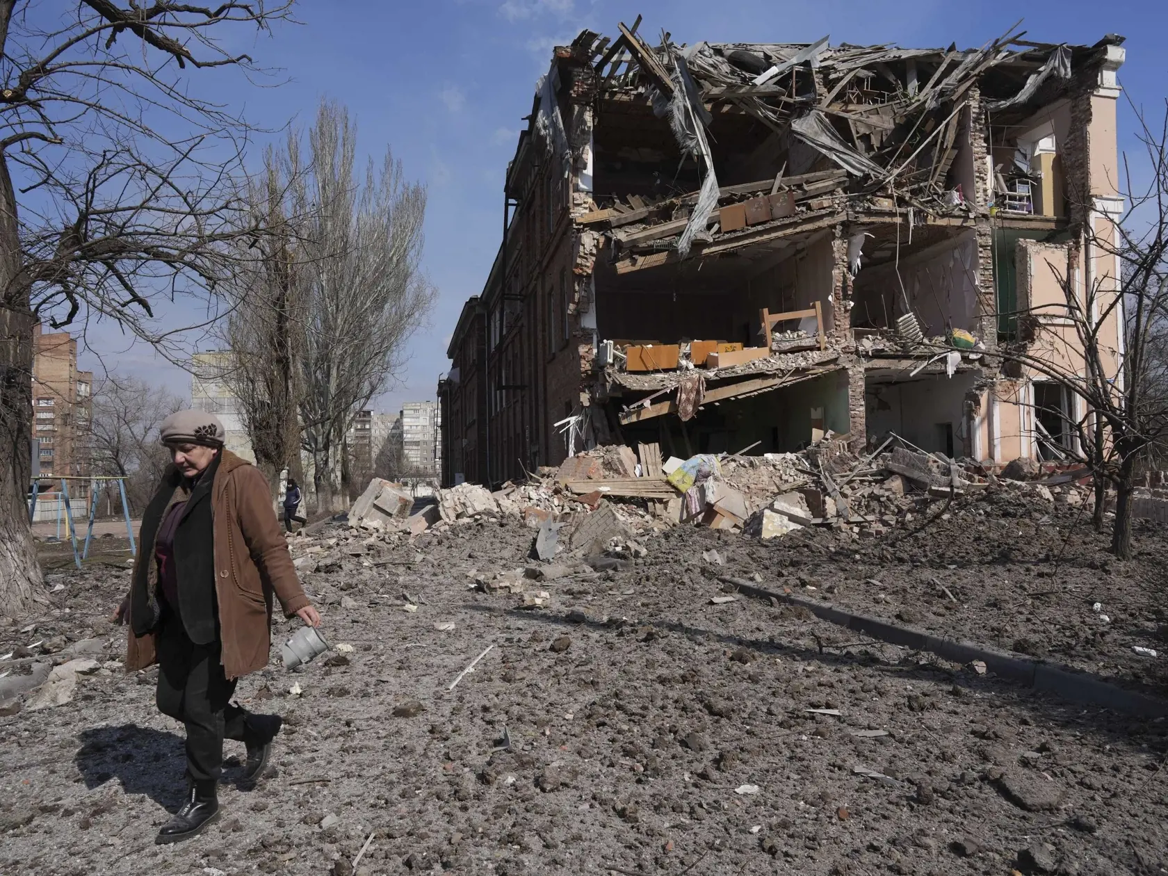 KK41 Mariupol - Žena kráča okolo budovy po ostreľovaní v prístavnom meste Mariupol na juhovýchode Ukrajiny počas 18. dňa ruskej invázie na Ukrajine v nedeľu 13. marca 2022. TASR/AP