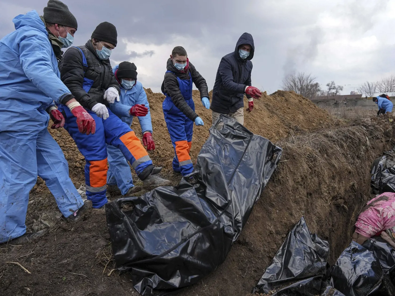 WA 15 Mariupol - Na snímke mŕtve telá ukladujú do masového hrobu v Mariupole počas štrnásteho dňa ruskej invázie na Ukrajine v stredu 9. marca 2022. FOTO TASR/AP