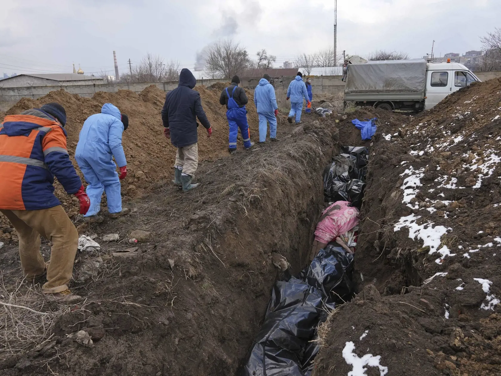 WA 16 Mariupol - Na snímke mŕtve telá ukladujú do masového hrobu v Mariupole počas štrnásteho dňa ruskej invázie na Ukrajine v stredu 9. marca 2022. FOTO TASR/AP