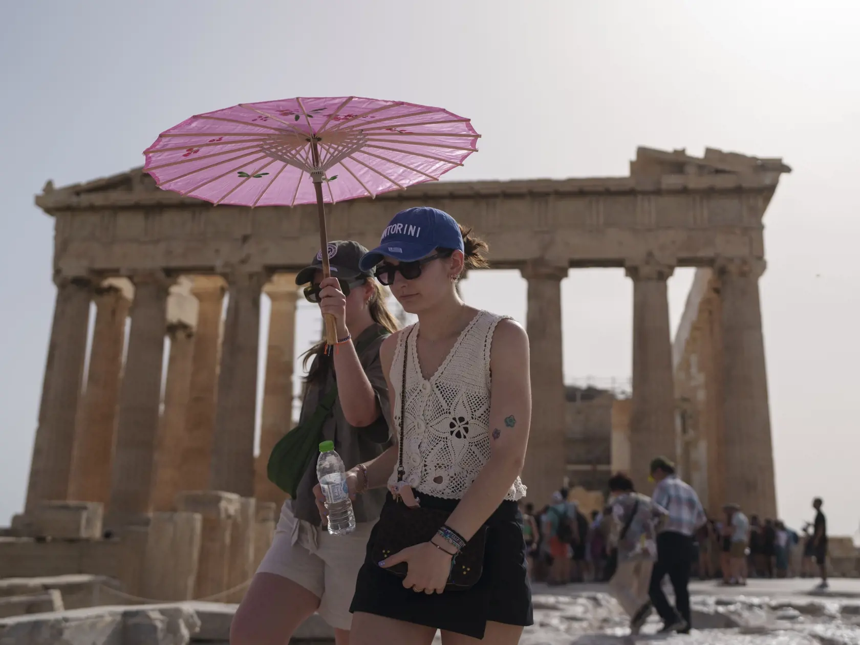 JB 21 Atémy - Turisti kráčajú s dáždnikom pred BC Parthenonom v starobylej Akropole v centrálnych Aténach 12. júna 2024. Aténska Akropola, najnavštevovanejšie turistické miesto v Grécku, bola v stredu počas najväčších horúčav pre verejnosť zatvorená, oznámilo tamojšie ministerstvo kultúry. TASR o tom informuje podľa agentúry AFP. V stredu a vo štvrtok počas prvej tohtoročnej vlny horúčav očakávajú v Aténach teplotu až 43 stupňov Celzia, spresnilo ministerstvo. Horúčavy v Grécku by mali vrcholiť 