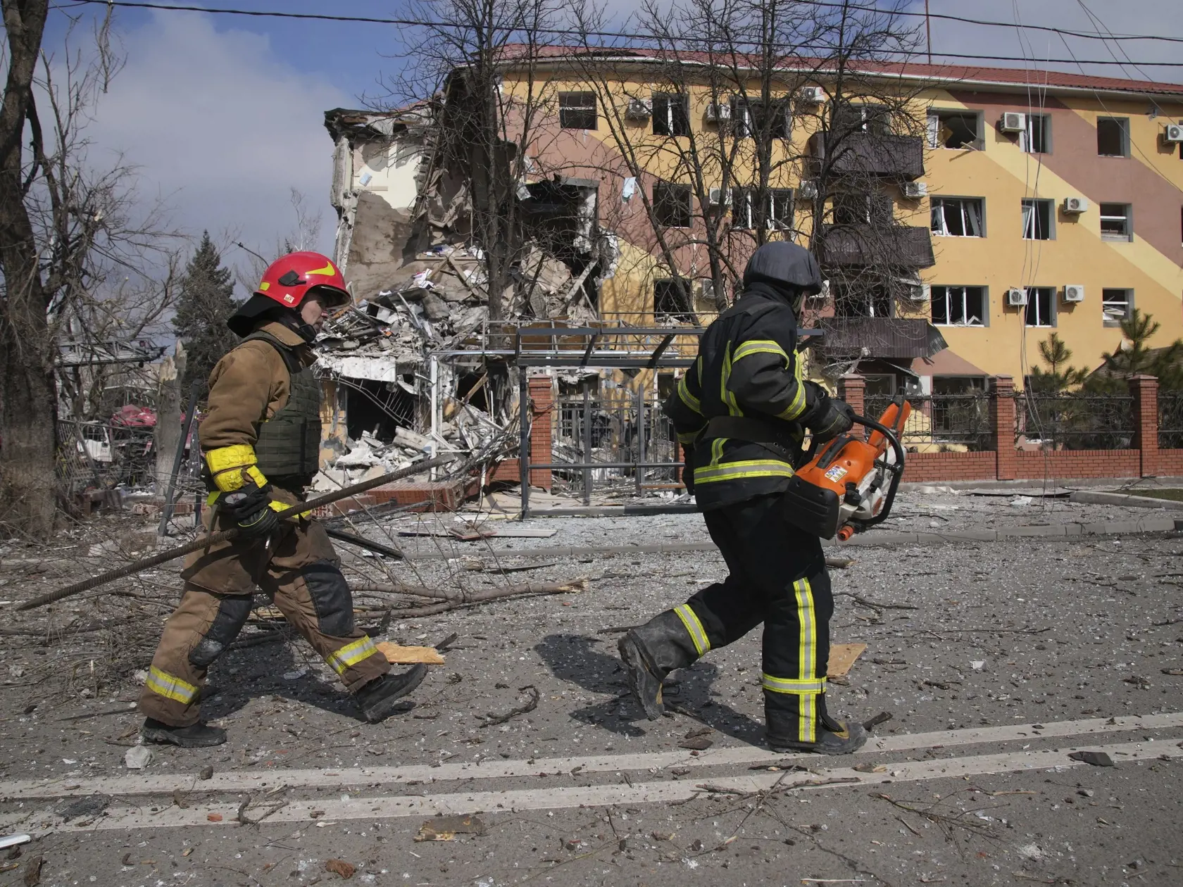 KK53 Mariupol - Hasiči kráčajú okolo zničenej budovy počas pätnásteho dňa ruskej invázie na Ukrajine vo štvrtok 10. marca 2022. FOTO TASR/AP