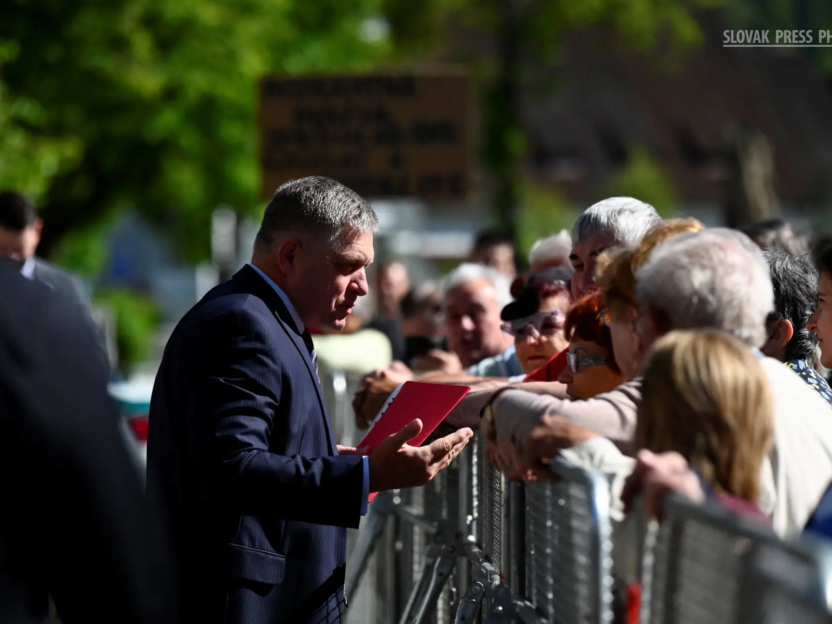 Premiér Robert Fico víta ľudí pred streľbou, pri ktorej bol zranený, v Handlovej 15. mája 2024. Ide o jeden zo série záberov fotografa Radovana Stoklasu. 