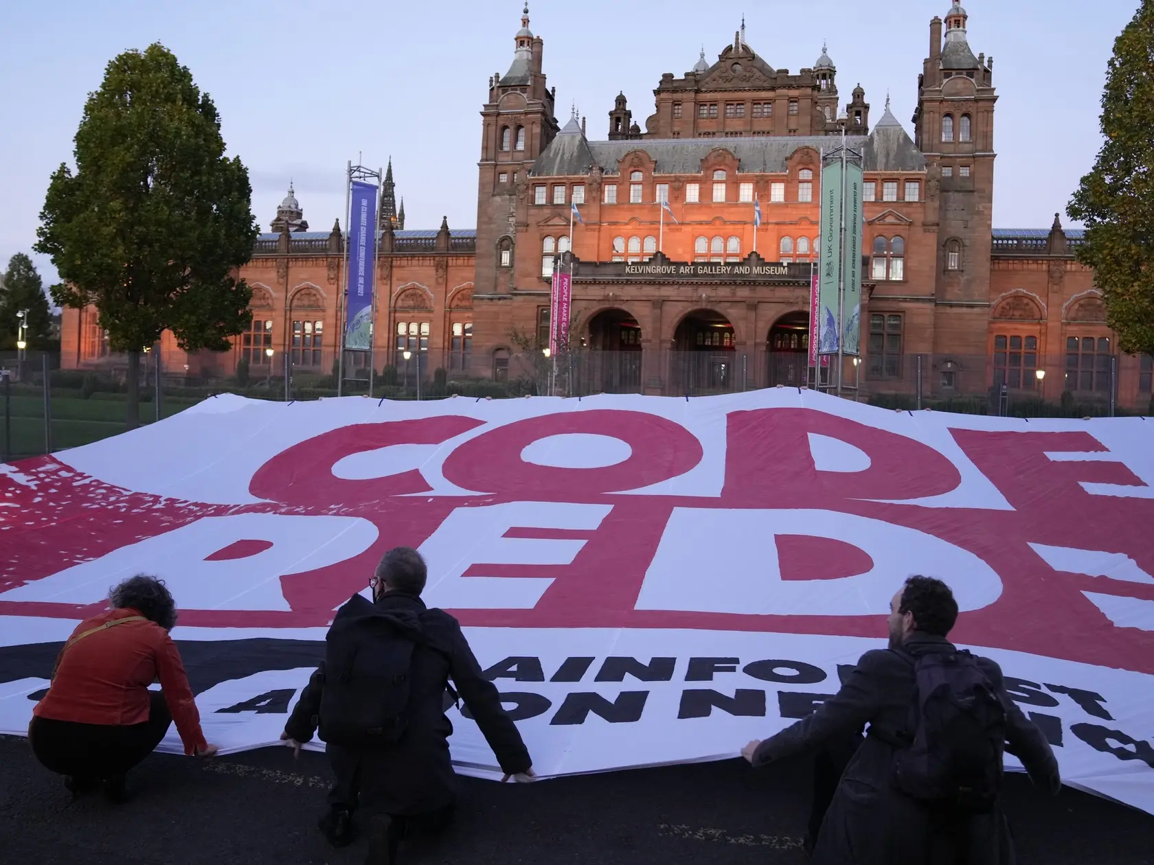 JB 8 Glasgow - Klimatickí aktivisti blokujú dopravu po tom, ako rozprestreli obrovský banner s nápisom "Code Red" pred budovou Múzea a galérie Kelvingrove počas klimatického summitu COP26 v Glasgowe 3. novembra 2021. Klimatická konferencia OSN v Glasgowe, známa aj pod skratkou COP26, sa považuje za najvýznamnejšie globálne klimatické fórum od prijatia Parížskej klimatickej dohody v roku 2015. Dvojtýždňové podujatie odštartovalo Fórum svetových lídrov. FOTO TASR/AP
Climate activists unfurl a la