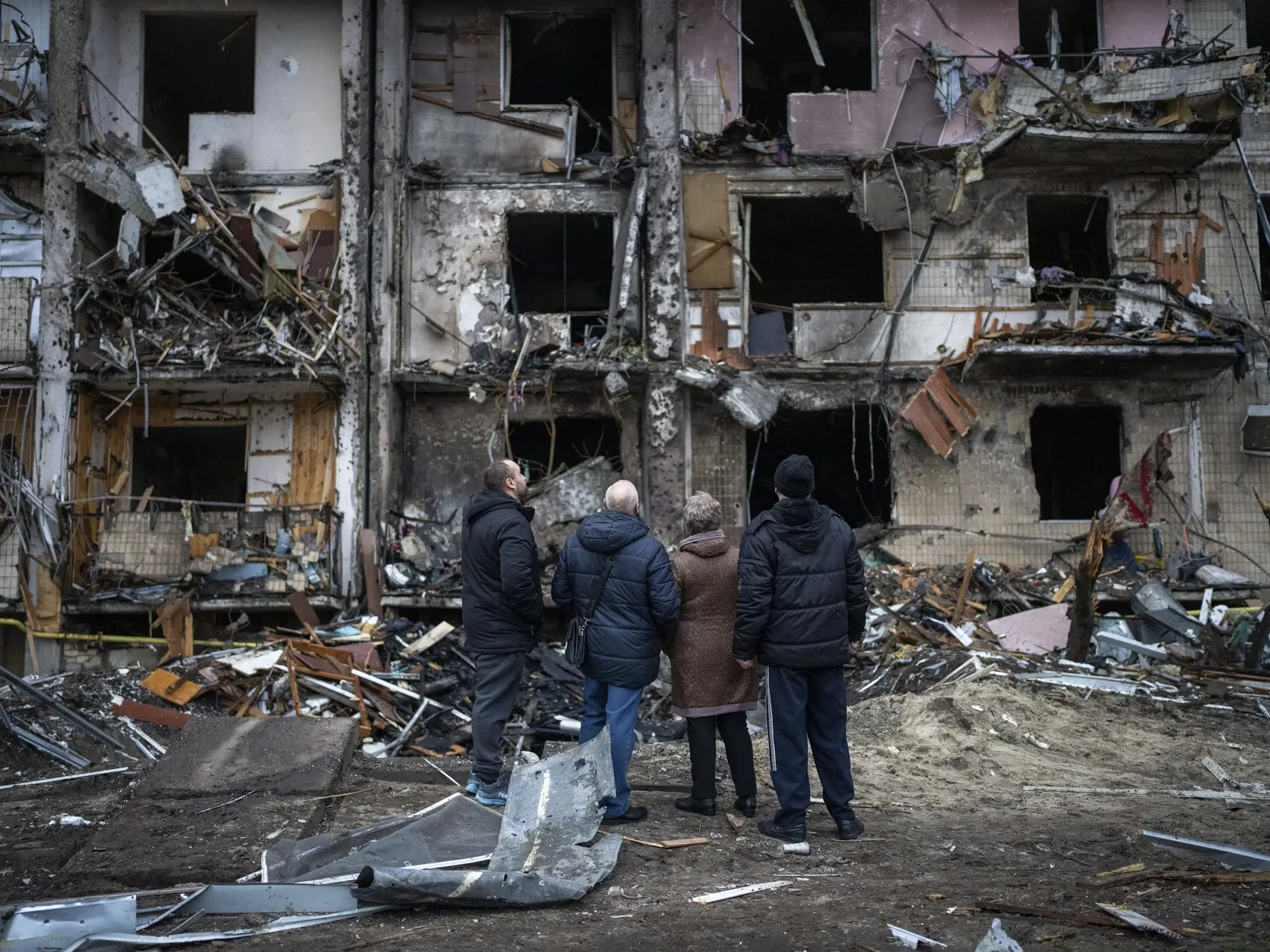 WA 11 Kyjev - Ľudia sa pozerajú na zničenú bytovku po raketovom útoku ruskej armády v ukrajinskej metropole Kyjev v piatok 25. februára 2022. FOTO TASR/AP