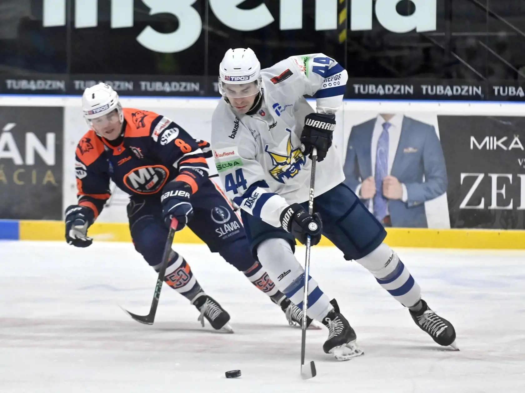 Na snímke zľava Aron Chmielewski (Michalovce)  a Juraj Valach (Spišská Nová Ves) bojujú o puk v zápase 37. kola hokejovej Tipos extraligy HK Dukla Ingema Michalovce - HK Spišská Nová Ves v Michalovciach v nedeľu 12. januára 2025. FOTO TASR - Roman Hanc