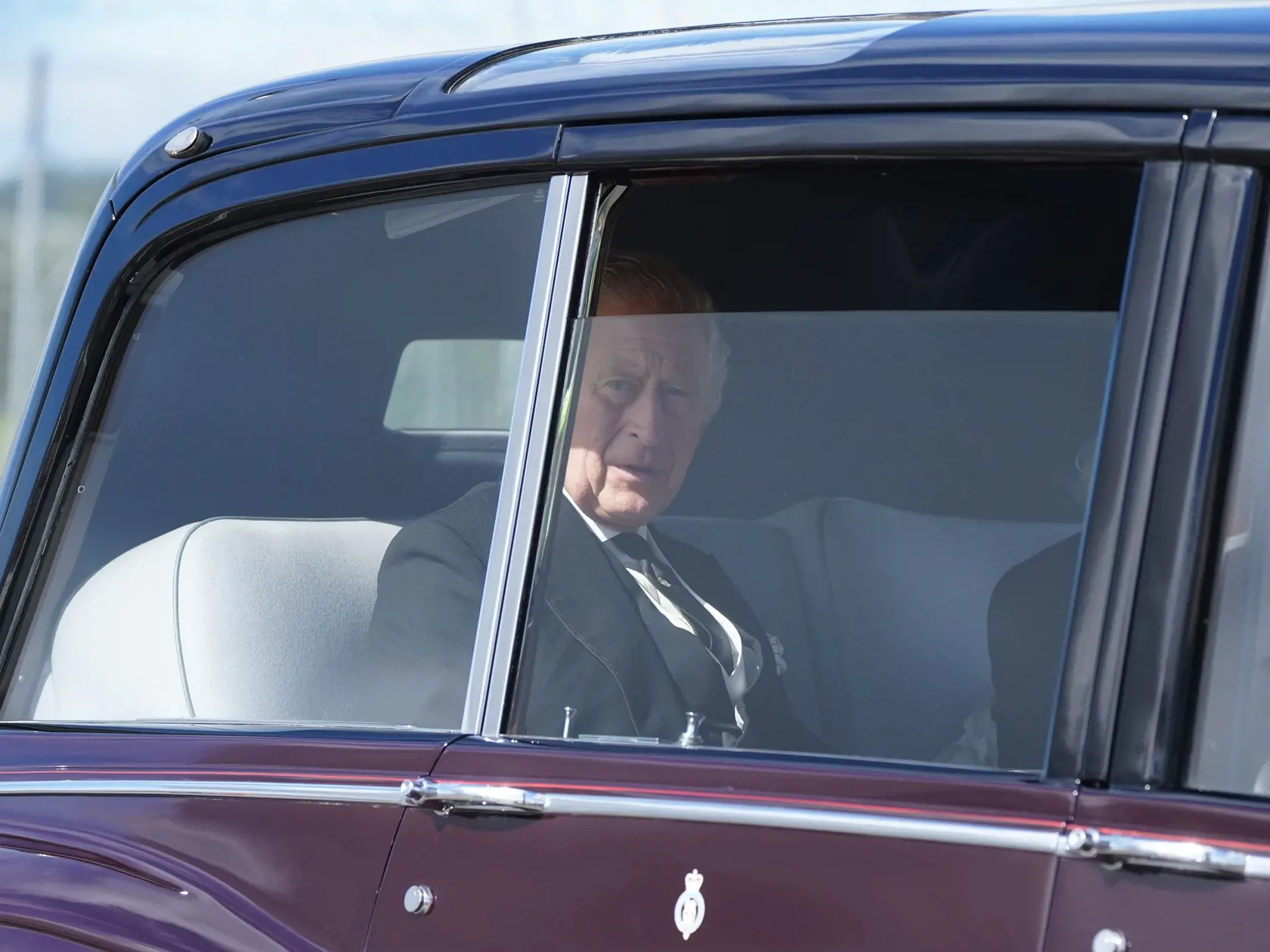 Britský kráľ Charles III. a Camilla, kráľovná manželka sedia v aute, ktoré ich vezie z letiska do Holyroodu, kde prevezme rakvu s telesnými pozostatkami svojej zosnulej matky Alžbety II. do Katedrály svätého Egídia v škótskom Edinburghu 12. septembra 2022. K