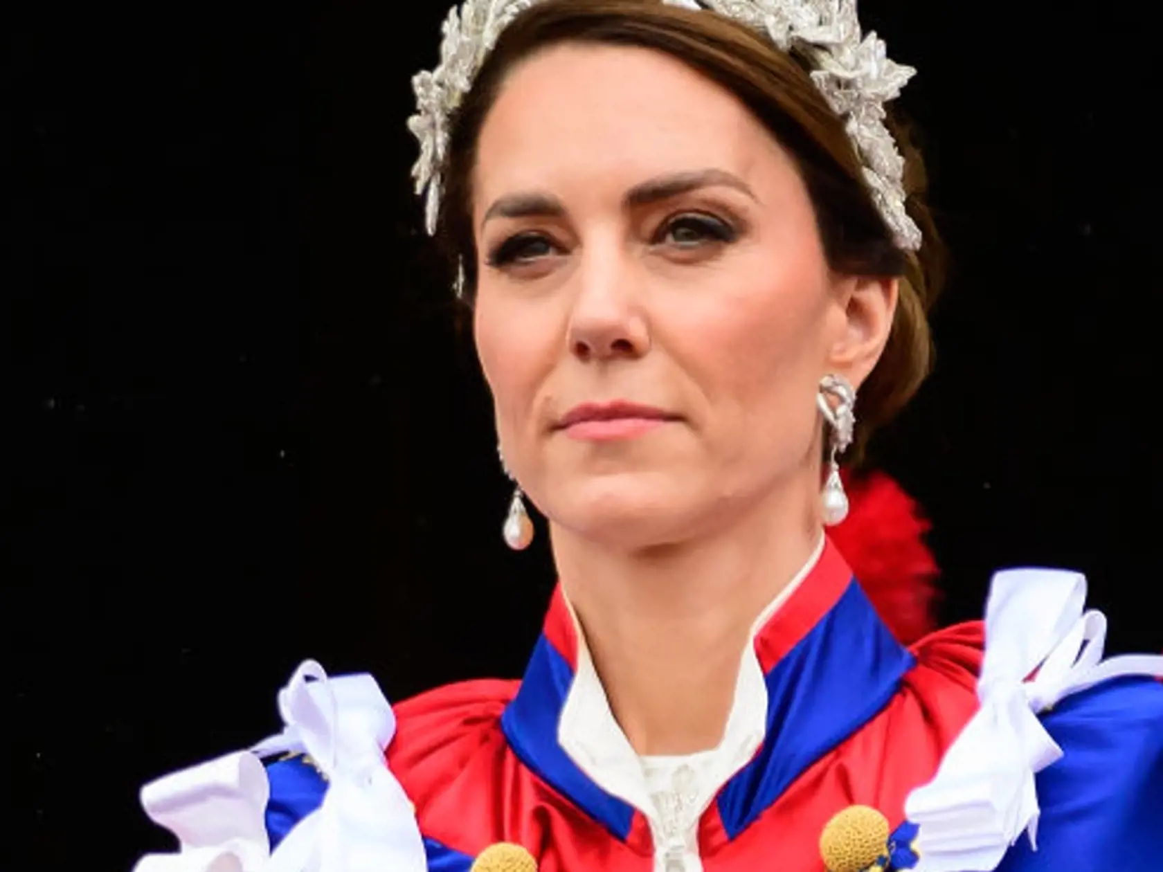 Princezná Kate mala na sebe tradičný ceremoniálny plášť. Pod ním slonovinové šaty od Alexandra McQueena a 3D čelenku, rovnako tak aj jej dcéra, princezná Charlotte.