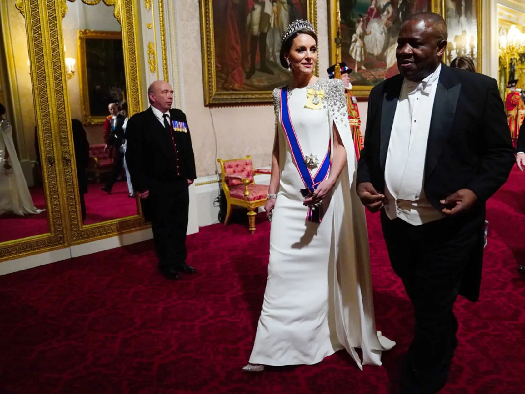 V šatách zdobených drahokamami, ktoré mali detaily peleríny oslnila všetkých účastníkov udalosti. Tento vzhľad veľmi pripomína aj outfit zosnulej princeznej Diany, ktorý mala na sebe počas oficiálnej návštevy Hongkongu v roku 1989.