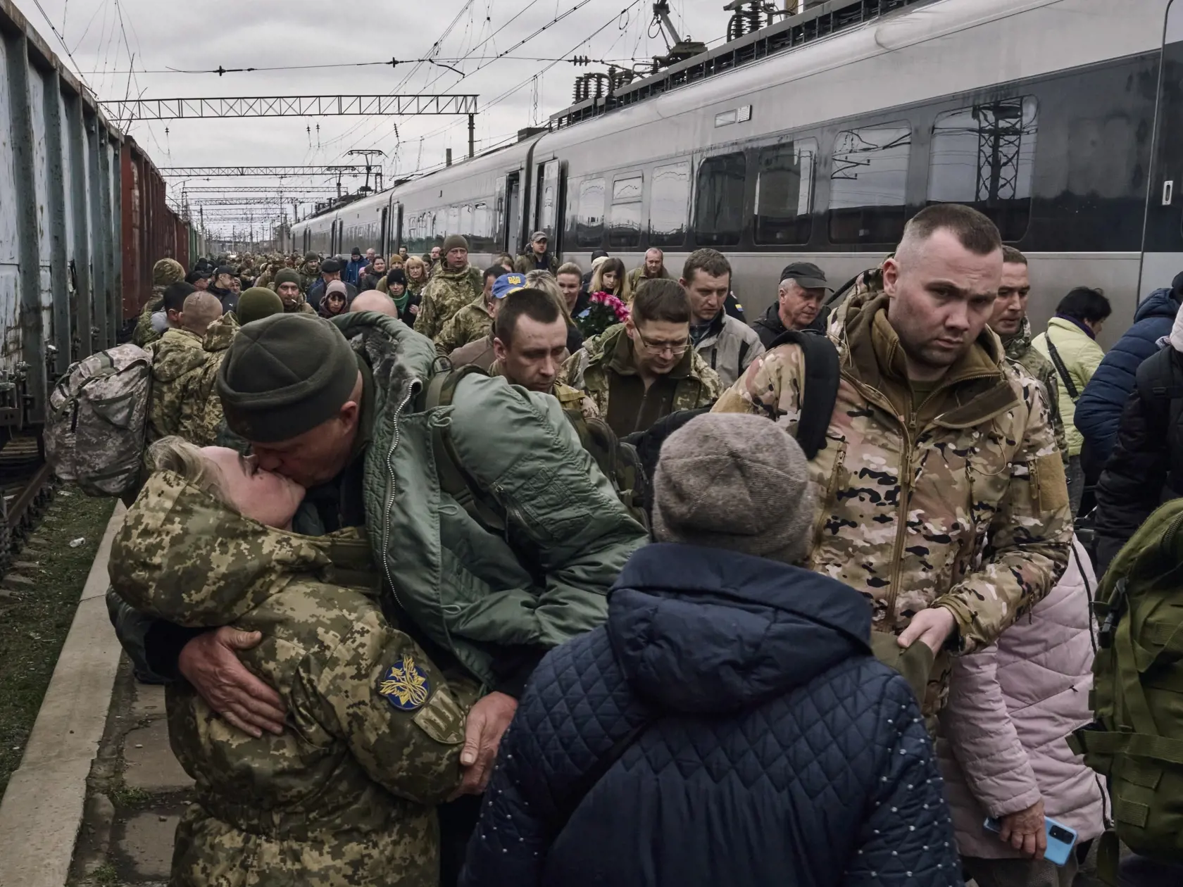 Ukrajinská vojačka (vľavo) bozkáva svojho manžela počas stretnutia na železničnej stanici v blízkosti frontovej línie v meste  Kramatorsk v Doneckej oblasti na východe Ukrajiny v stredu 29. marca 2023.