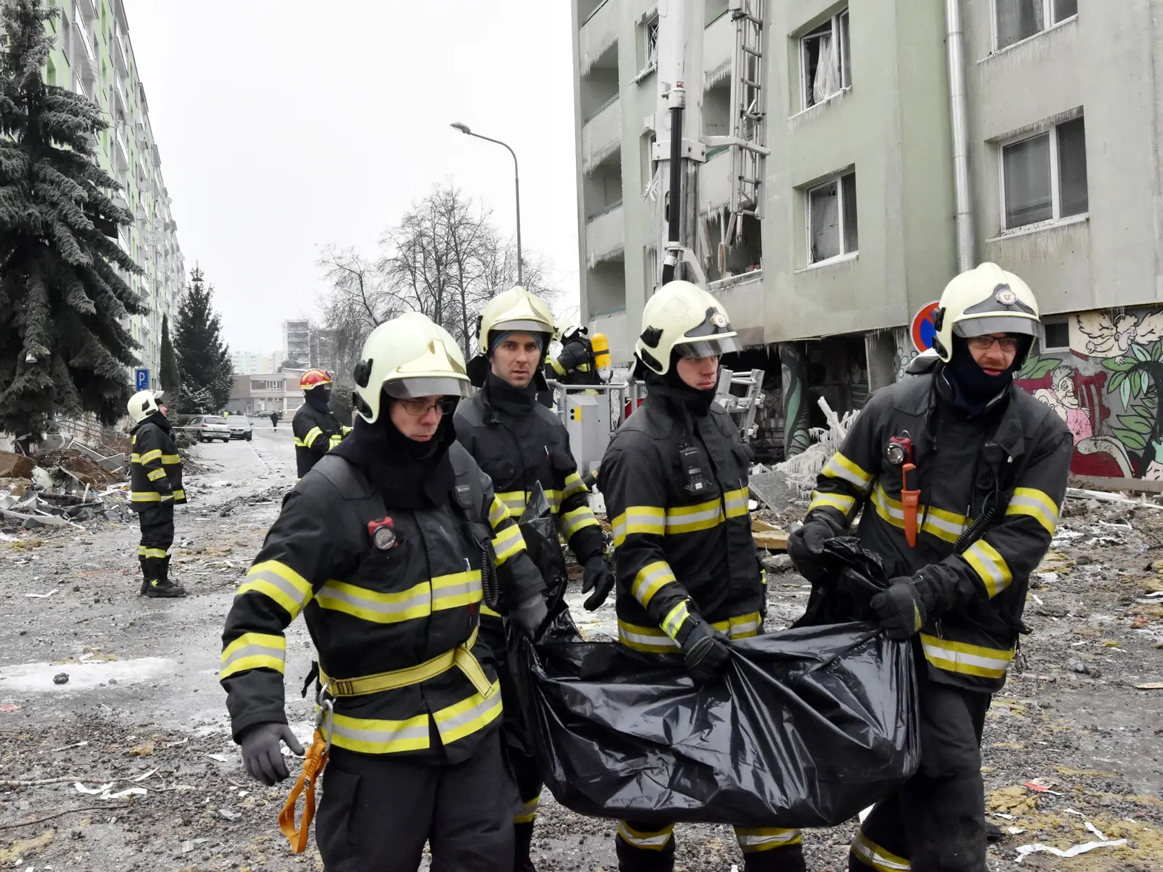 Hasiči nesú z trosiek panelového domu na Mukačevskej ulici v Prešove telesné pozostatky jednej z obetí ničivého výbuch plynu v sobotu 7. decembra 2019. FOTO TASR - TASR-Vladimír Benko/MV SR