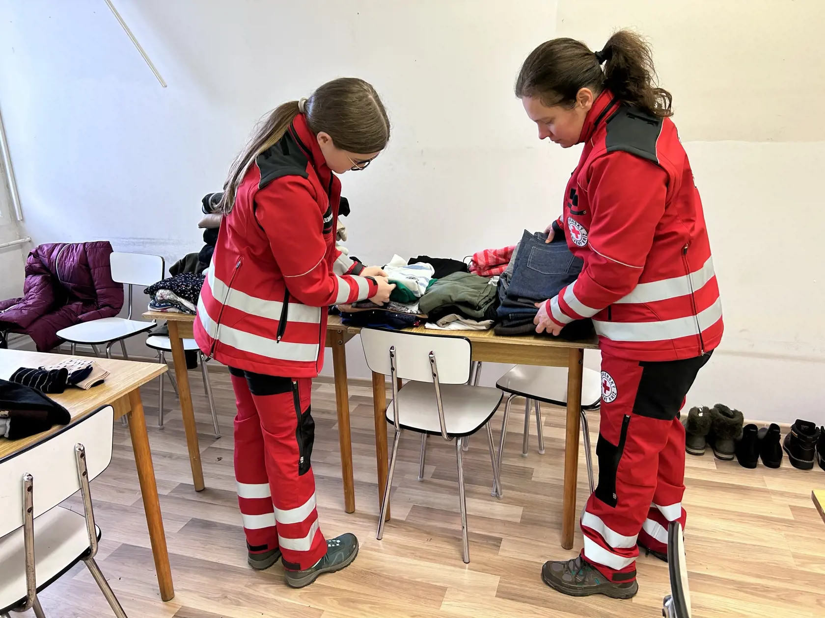 Dobrovoľníčky ČK Monika a Kristínka pri triedení vecí, ktoré doniesli ľudia