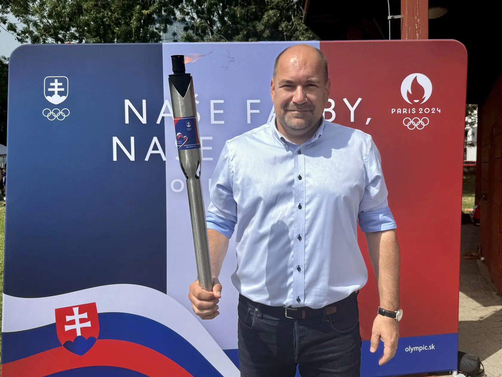 Minister cestovného ruchu a športu Dušan Keketi (nom. SNS) drží olympijskú pochodeň. 