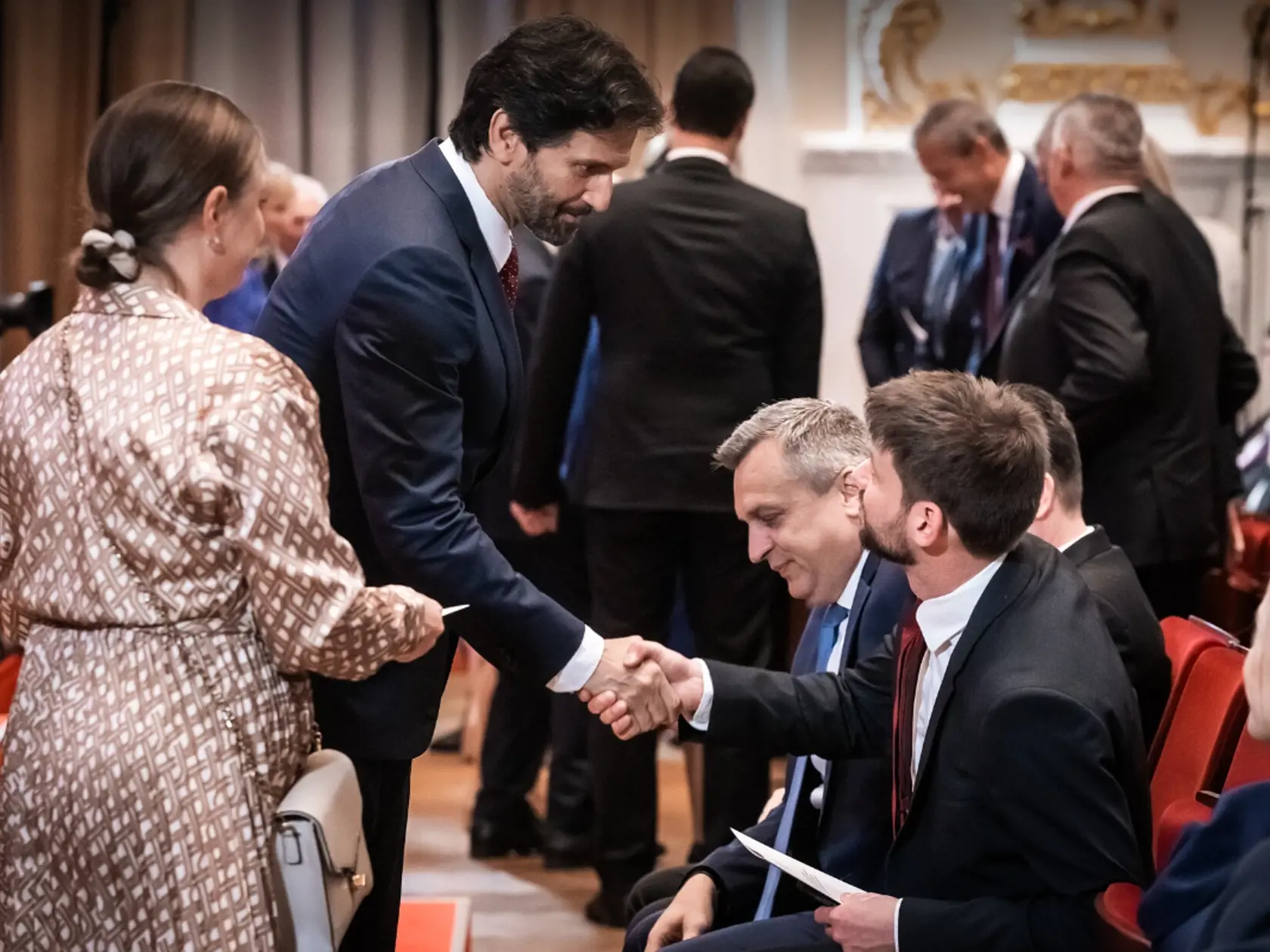 Minister obrany Robert Kaliňák si podáva ruku s predsedom Progresívneho Slovenska Michalom Šimečkom.
