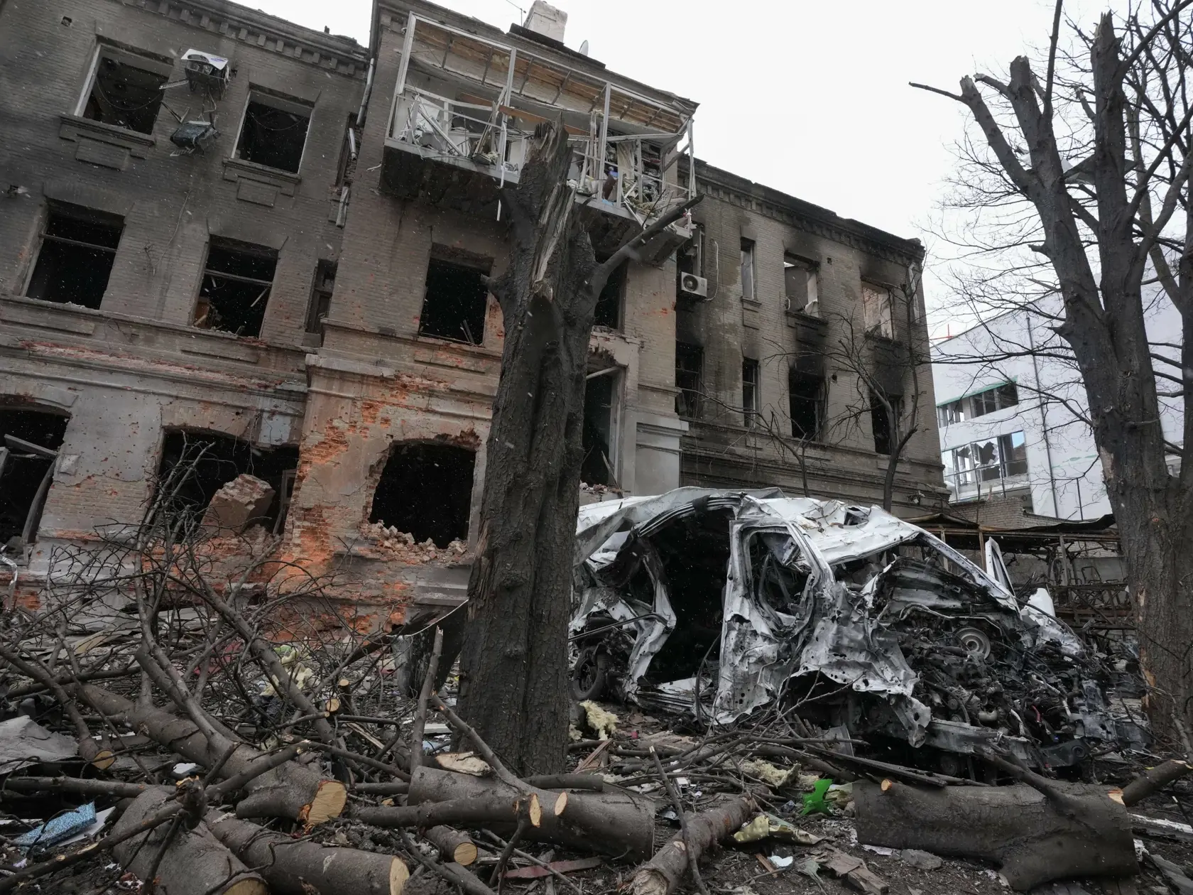 JB 70 Charkov - Zničená budova a auto po ruskom raketovom ostreľovaní v noci v centre Charkova 27. marca 2022. FOTO TASR/AP
