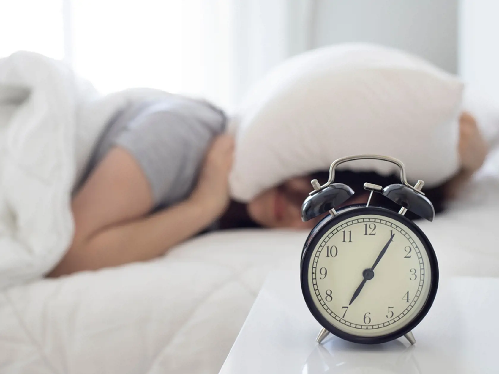 Irritated,Young,Woman,Putting,Her,Alarm,Clock,Off,In,The