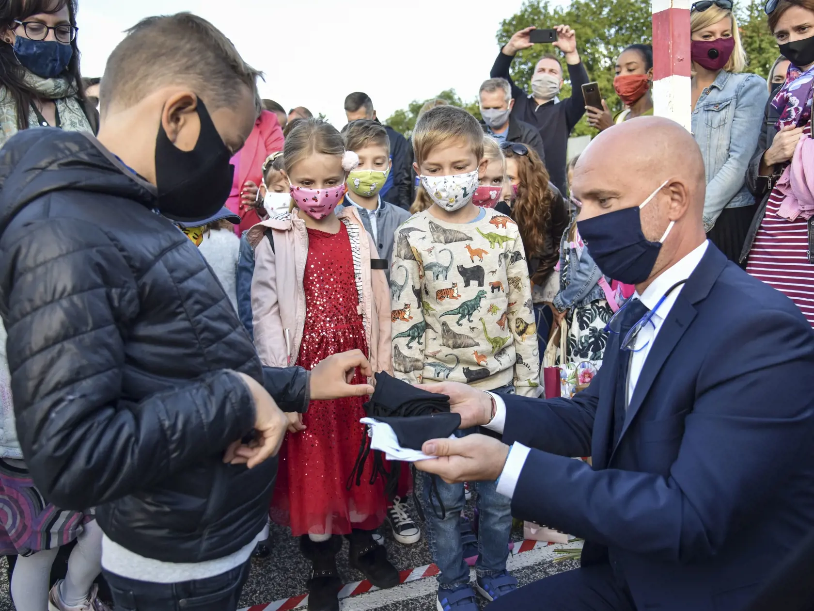 Na snímke minister školstva, vedy, výskumu a športu SR Branislav Gröhling rozdáva žiakom ochranné rúška počas slávnostného otvorenia školského roka 2020 - 2021 na Základnej škole kpt. Jána Nálepku v Stupave 2. septembra 2020. FOTO TASR - Pavol Zachar