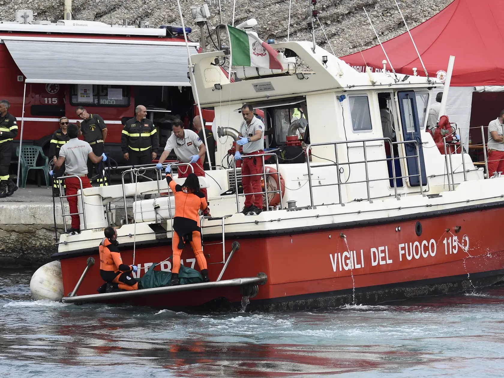 Talianski potápači vynášajú telo jednej z obetí potopenej plachetnice Bayesan v prístave v meste Porticello neďaleko Palerma na talianskom ostrove Sicília.