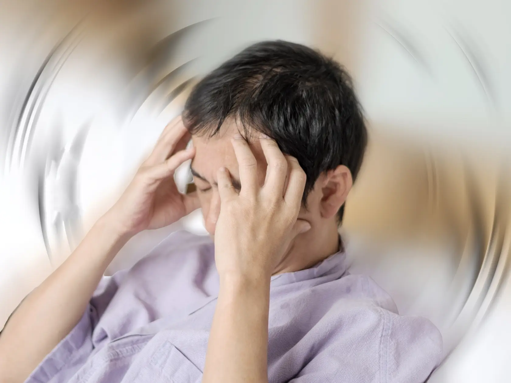 Vertigo illness concept. Man hands on his head felling headache dizzy sense of spinning dizziness,a problem with the inner ear, brain, or sensory nerve pathway.