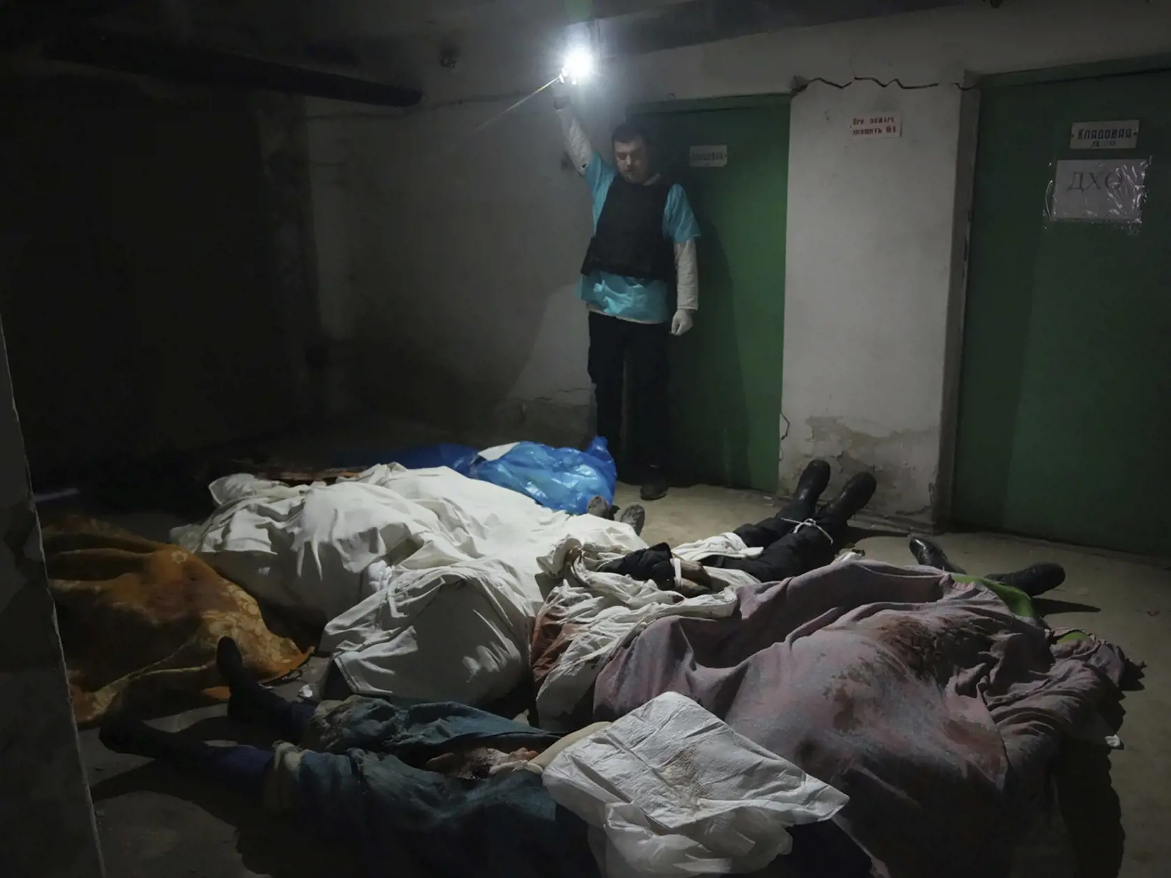 WA 23 Mariupol - Policajt svieti na zabalené telá obetí v nemocnici číslo 3, ktoré prišli o život počas ostreľovania v obliehanom meste Mariupol na juhovýchode Ukrajiny v utorok 15.marca 2022. FOTO TASR/AP 


A police officer shows the covered bodies of people killed by shelling at hospital number 3 in Mariupol, Ukraine, Tuesday, March 15, 2022. (AP Photo/Evgeniy Maloletka)