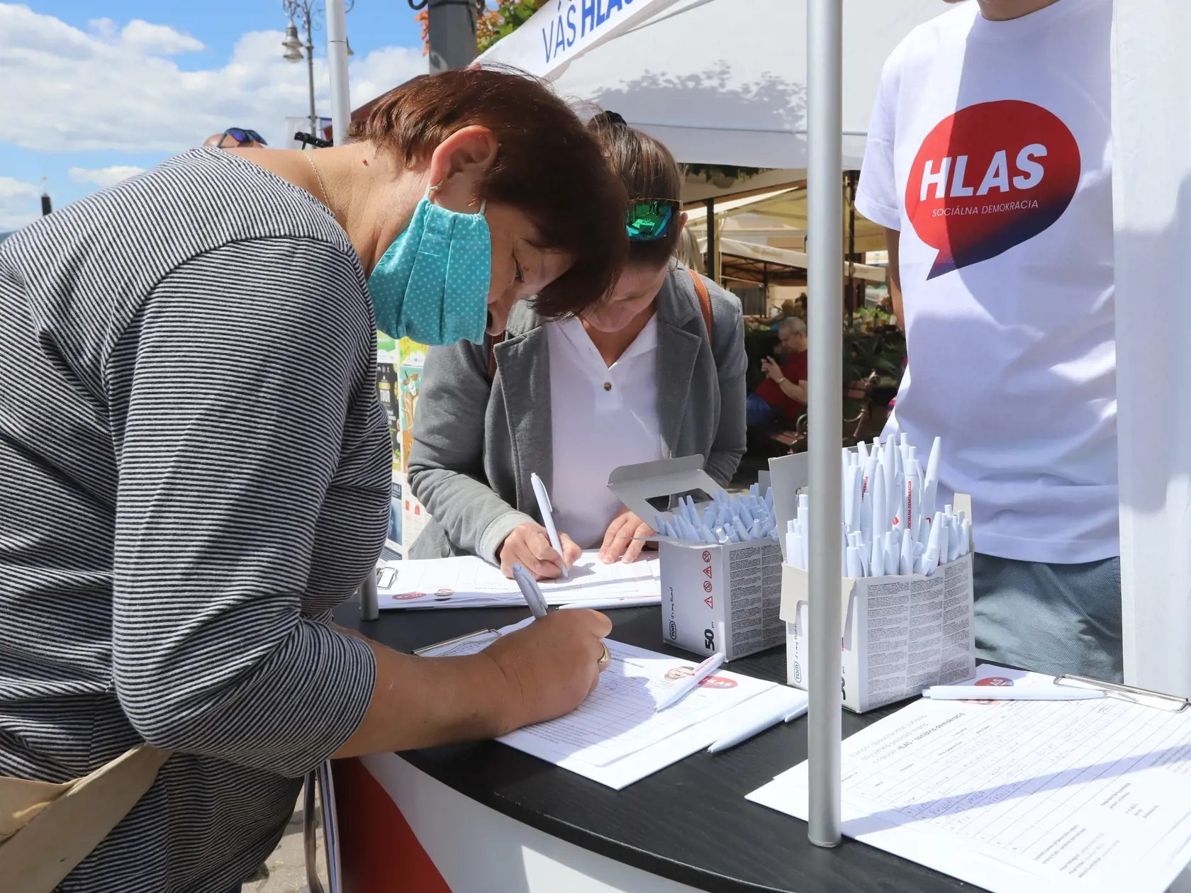 Na snímke ľudia podpisujú hárky za vznik novej politickej strany expremiéra Petra Pellegriniho HLAS – sociálna demokracia. V Banskej Bystrici 13. júla 2020. FOTO TASR - Ján Krošlák