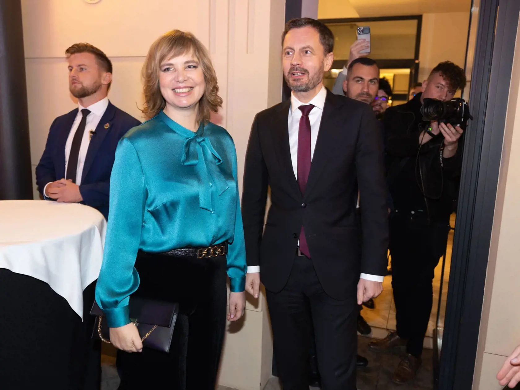 Vicepremiérka Veronika Remišová s premiérom Eduardom Hegerom po tom, ako Európska komisia schválila operačný Program Slovensko. Ministerka prekvapila elegantným outfitom: čierne zamatové nohavice s vintage nádychom skombinovala s tmavozelenou blúzkou z lesklého saténu a s ozdobnou mašľou.
