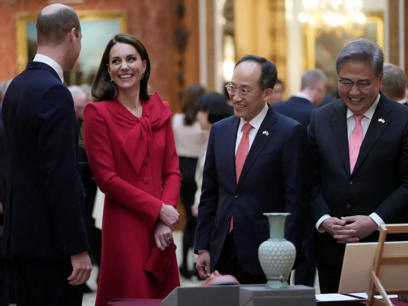 Princezná z Walesu Kate v šarlátových šatách s juhokórejským námestníkom premiéra Choo Kyung-hom a ministrom zahraničia Park Jinom.
