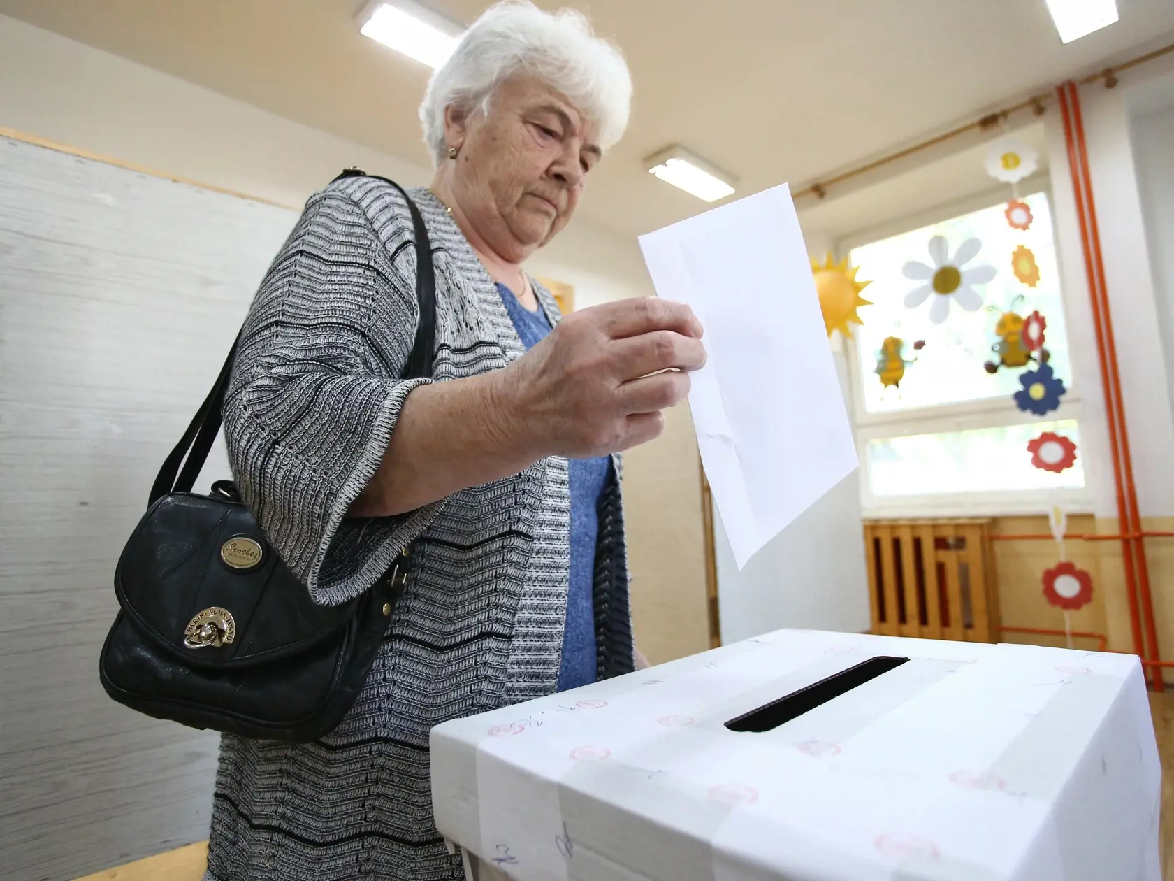 Na snímke volička vhadzuje obálku s hlasovacím lístkom do volebnej schránky vo voľbách do Európskeho parlamentu v sobotu 8. júna 2024 v Rajci, okres Žilina.
