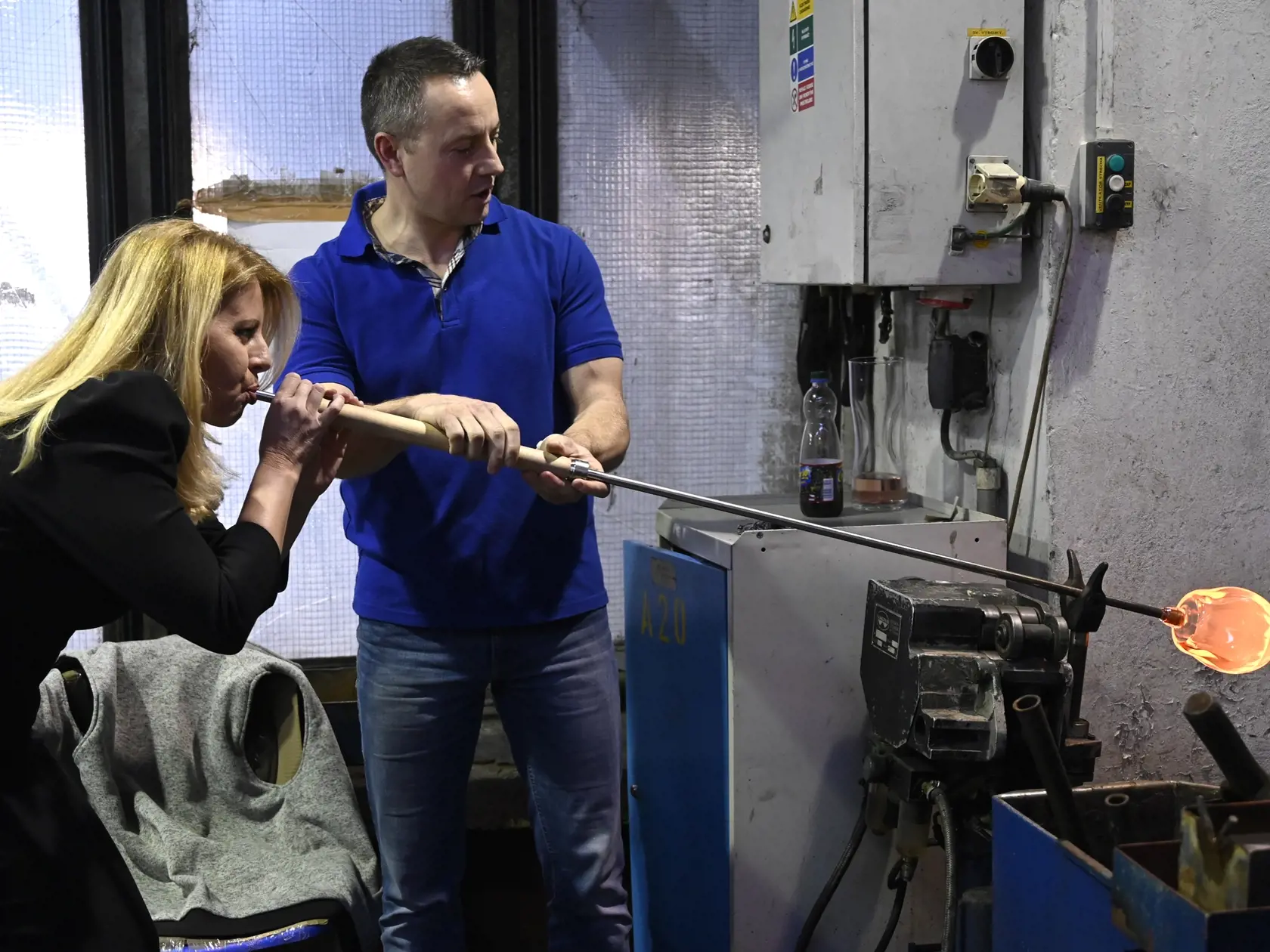 Na snímke vľavo prezidentka SR Zuzana Čaputová fúka pohár zo skla počas prehliadky sklární spoločnosti RONA vo štvrtok 16. januára 2020 v Lednických Rovniach.