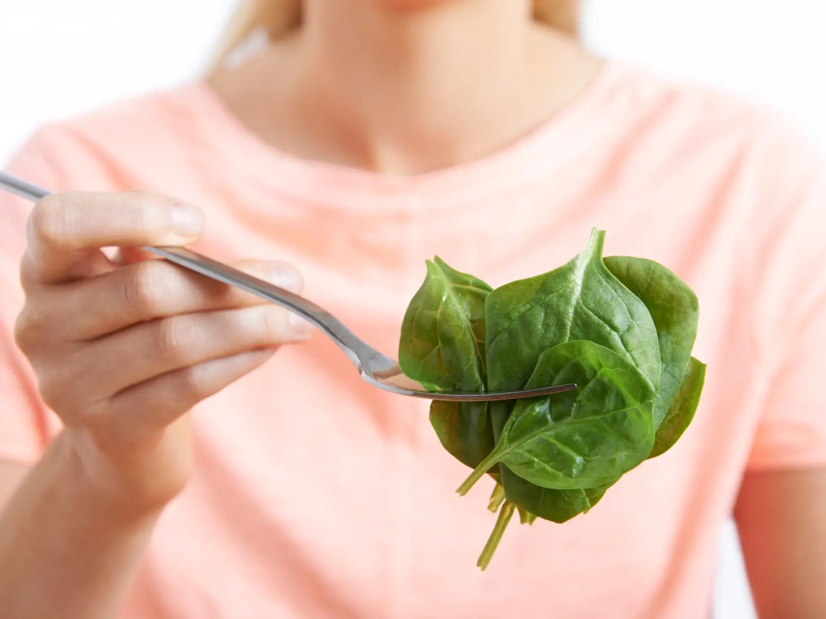 Close,Up,Of,Woman,With,Spinach,On,Fork