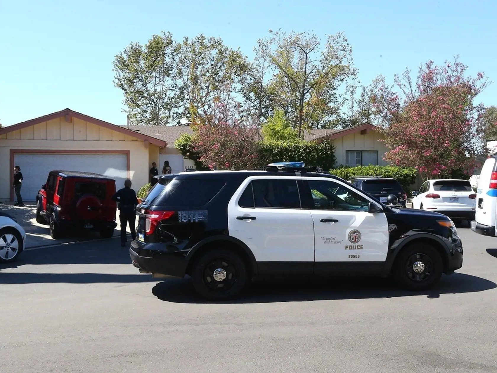 Polícia, priatela a rodina pred raperovym domom v Los Angeles.