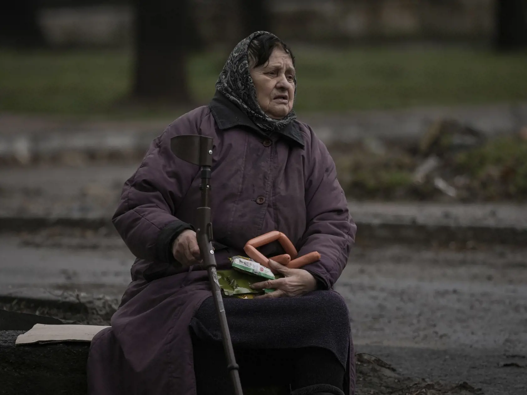 KK52 Buča - Žena drží jedlo po príchode vojenského konvoja a konvoja vozidiel s humanitárnou a ostatnou pomocou v meste Buča pri Kyjeve počas 38. dňa ruskej invázie na Ukrajinu v sobotu 2. apríla 2022. Ukrajinský minister zahraničných vecí Dmytro Kuleba žiada členské štáty G7, aby v reakcii na vraždenie civilistov v ukrajinskom meste Buča okamžite prijali nové sankcie voči Rusku. Podľa agentúry AFP to Kuleba uviedol vo svojom tweete zverejnenom v nedeľu. "Masakry v Buči boli úmyselné. Rusi sa sn