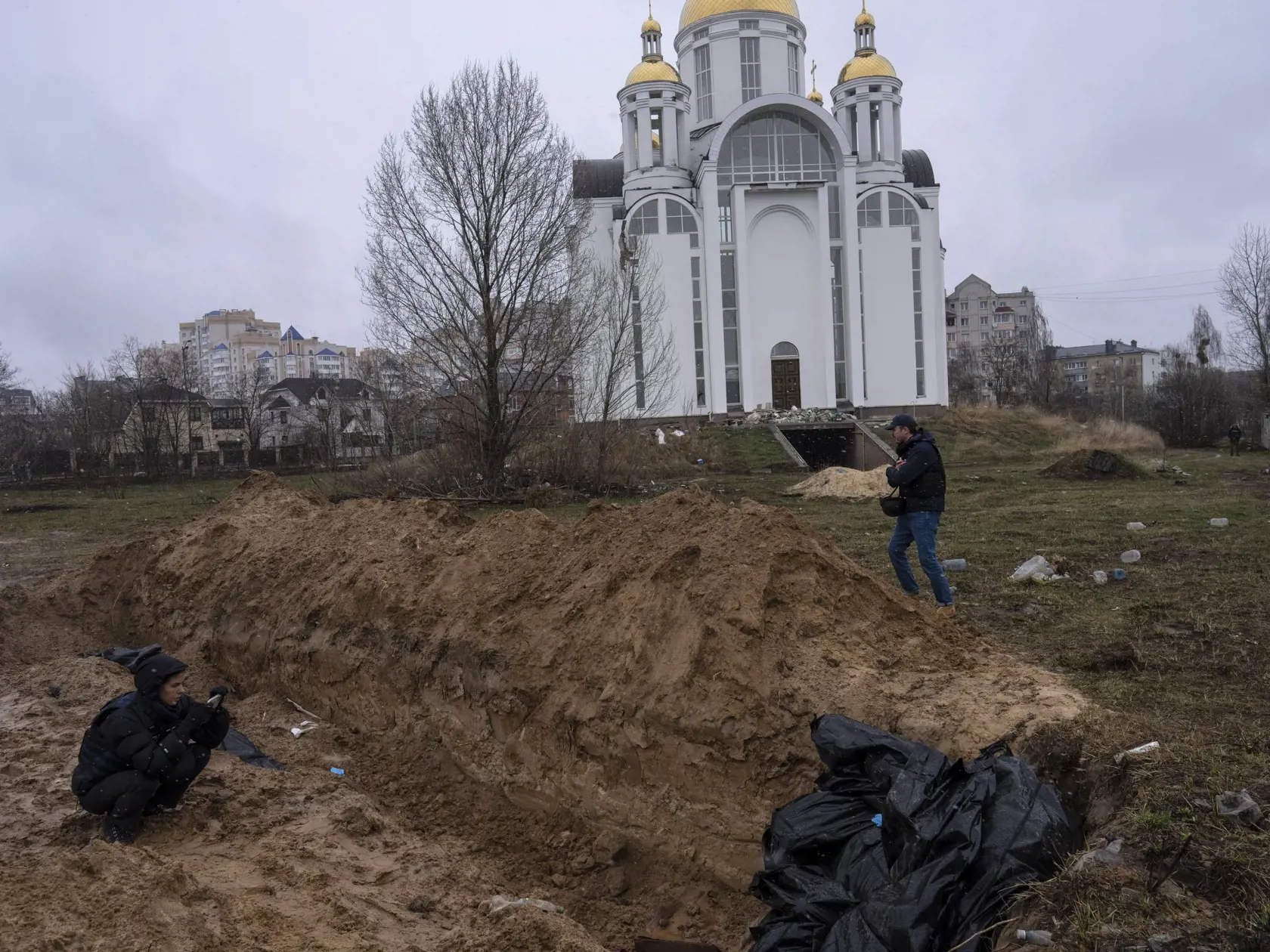 Ukrajinskí záchranári objavili za kostolom v centre mesta Buča asi 17-metrový zákop, v ktorom našli 57 tiel. Niektoré z nich boli v čiernych plastových vreciach, zatiaľ čo ostatné boli v civilnom odeve.