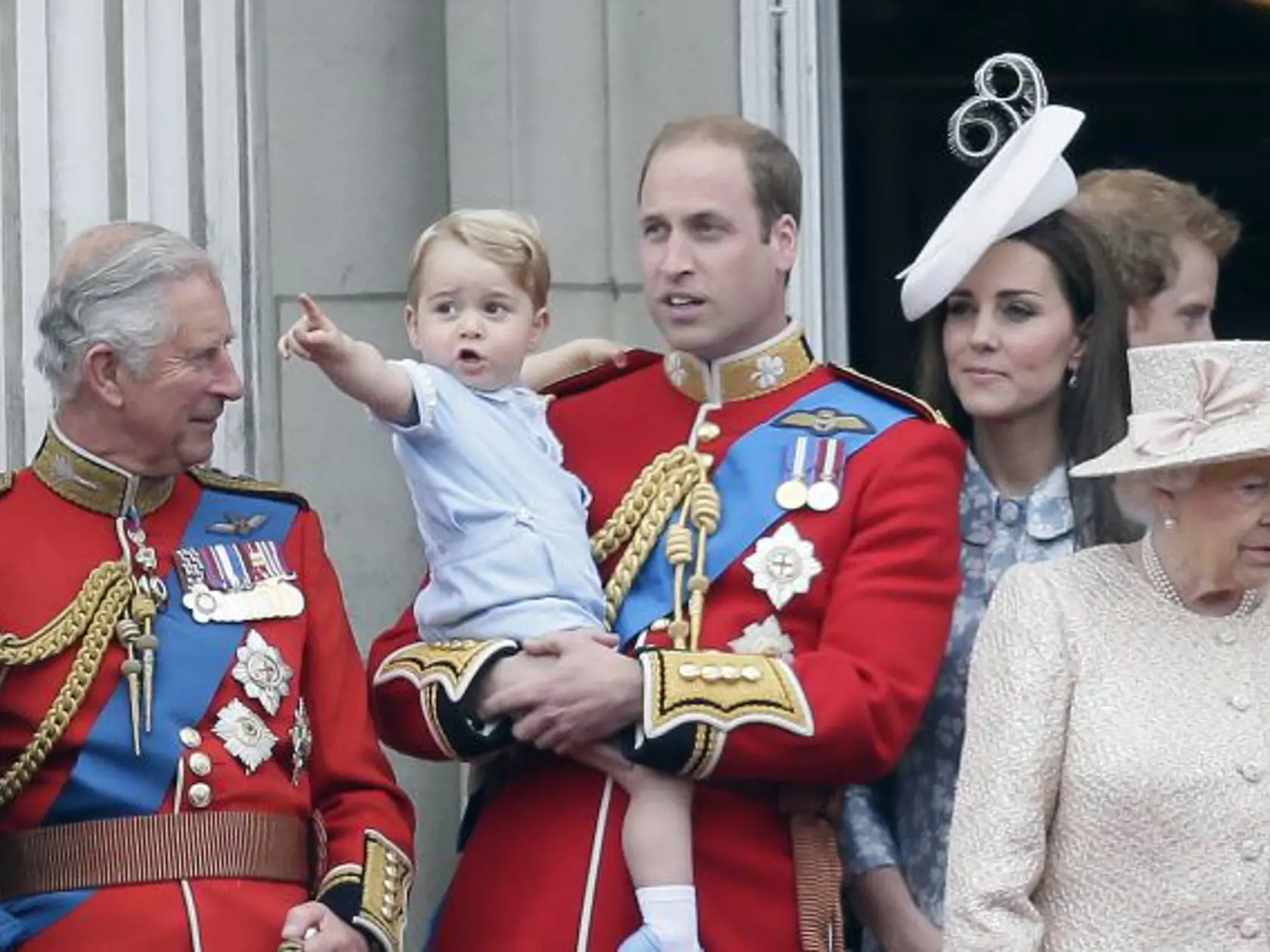 Britský princ William drží svojho syna princa Georga, vpravo britská kráľovná Alžbeta II. , druhá vpravo Kate, vojvodkyňa z Cambridge a vľavo britský princ Charles sa pozerajú z balkóna počas vojenskej prehliadky Trooping the Colour v rámci osláv 89. narodenín britskej kráľovnej Alžbety II.