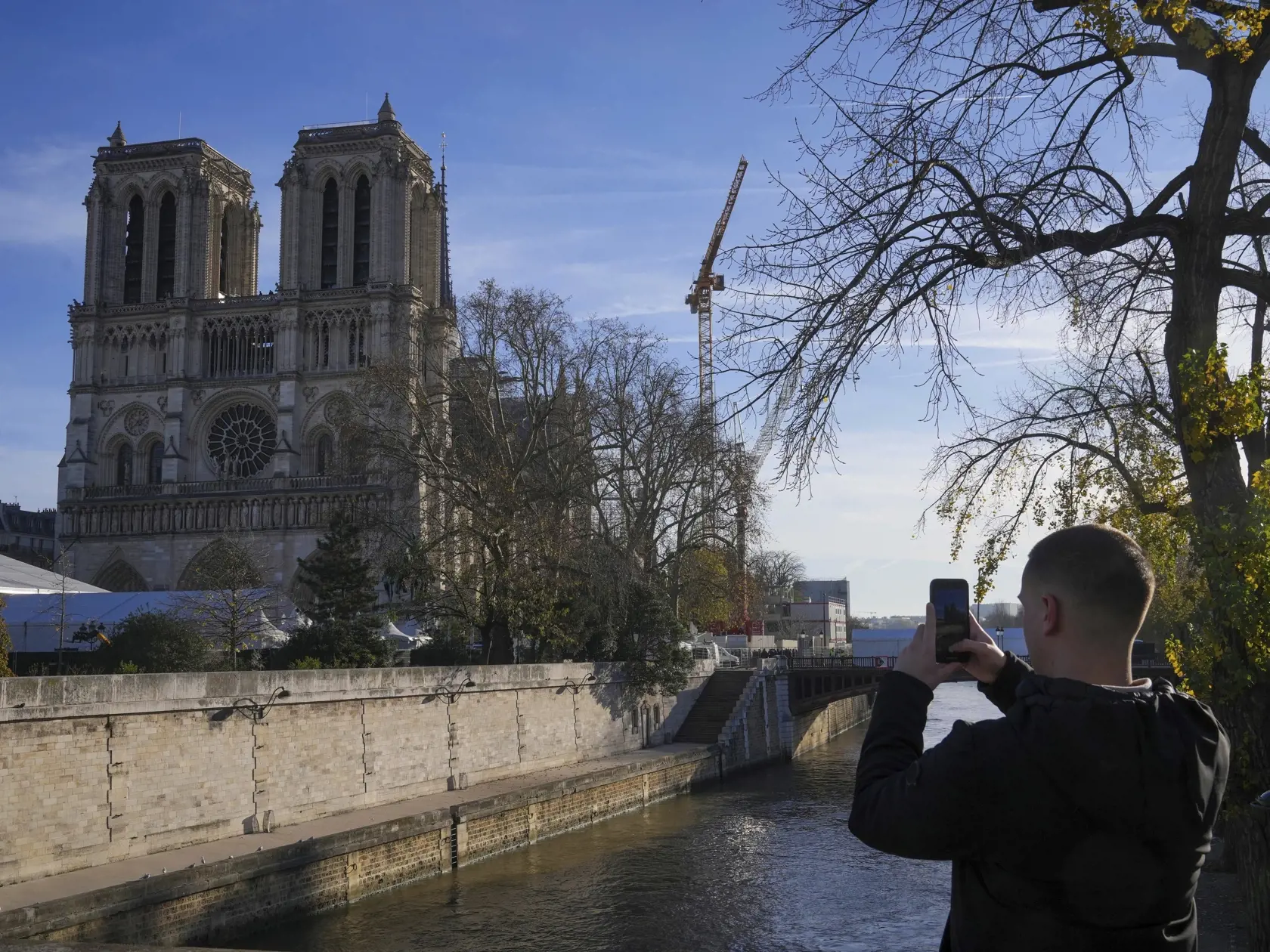 WA 54 Paríž - Muž si fotí zrekonštruovanú parížsku katedrálu Notre- Dame, ktorú navštívil francúzsky prezident Emmauel Macron v piatok 29. novembra 2024. Katedrálu pred piatimi rokmi významne poškodil požiar. Pamiatka zapísaná v svetovom dedičstve UNESCO bude slávnostne znovuotvorená v sobotu 7. decembra. FOTO TASR/AP

A man takes a picture of Notre Dame Cathedral as French President Emmanuel Macron visits the renovated cathedral, Friday, Nov. 29, 2024 in Paris. (AP Photo/Michel Euler)