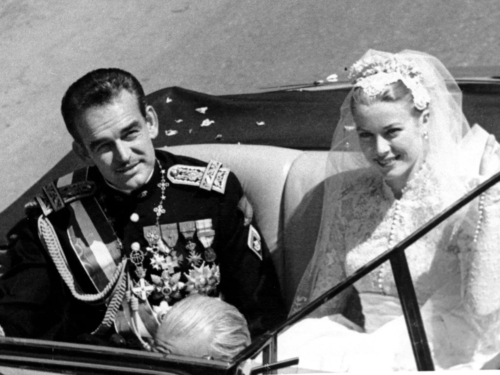Na archívnej snímke z 19. apríla 1956 princezná Grace Kellyová máva zástupom ľudí počas jazdy v otvorenom aute po sobáši s s princom Rainerom III , ktorá sa konala v katedrále v Monaku.